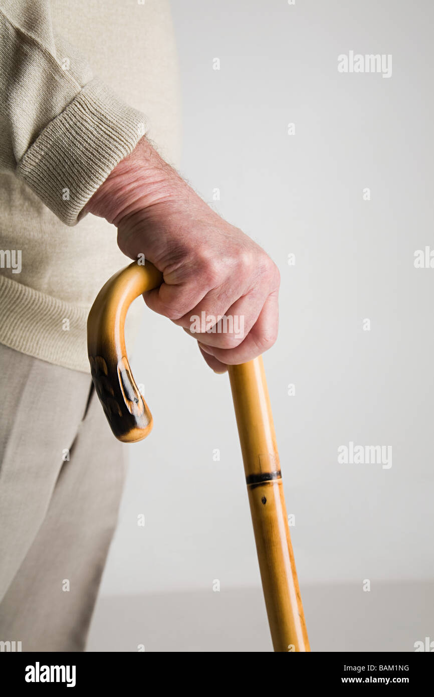Senior man holding walking stick Stock Photo