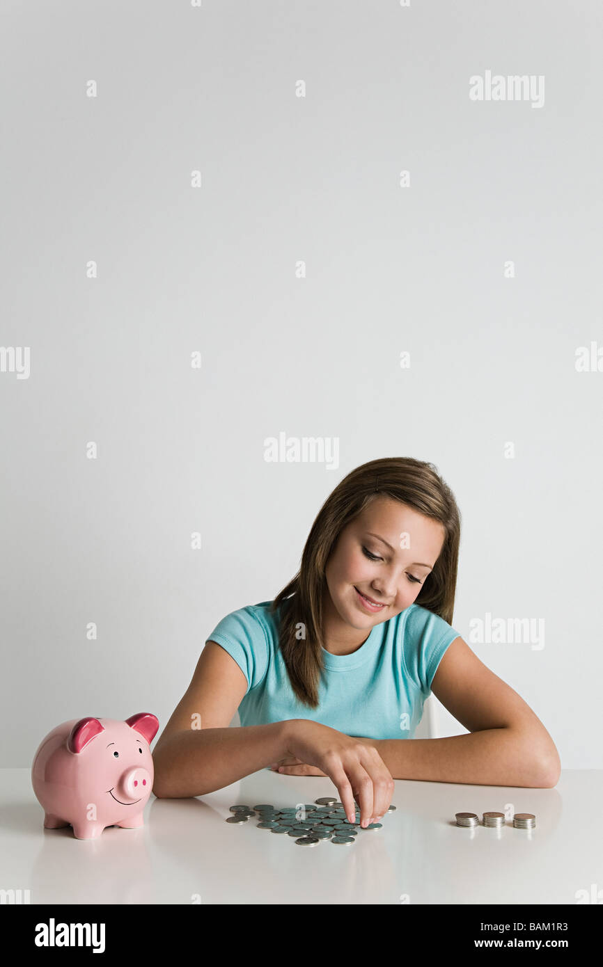 Girl with piggy bank and coins Stock Photo - Alamy