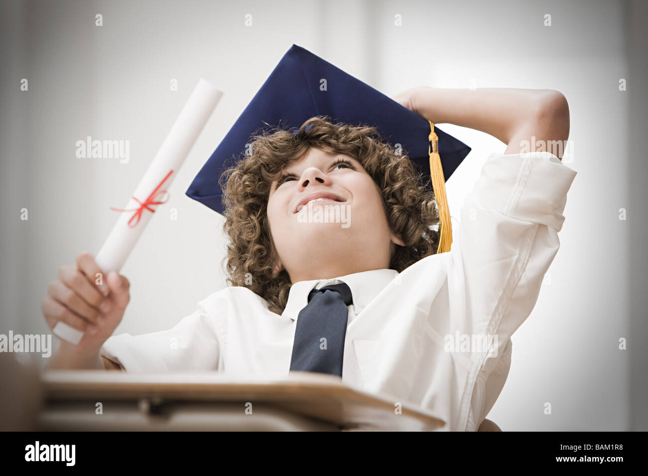 Graduating boy looking up Stock Photo