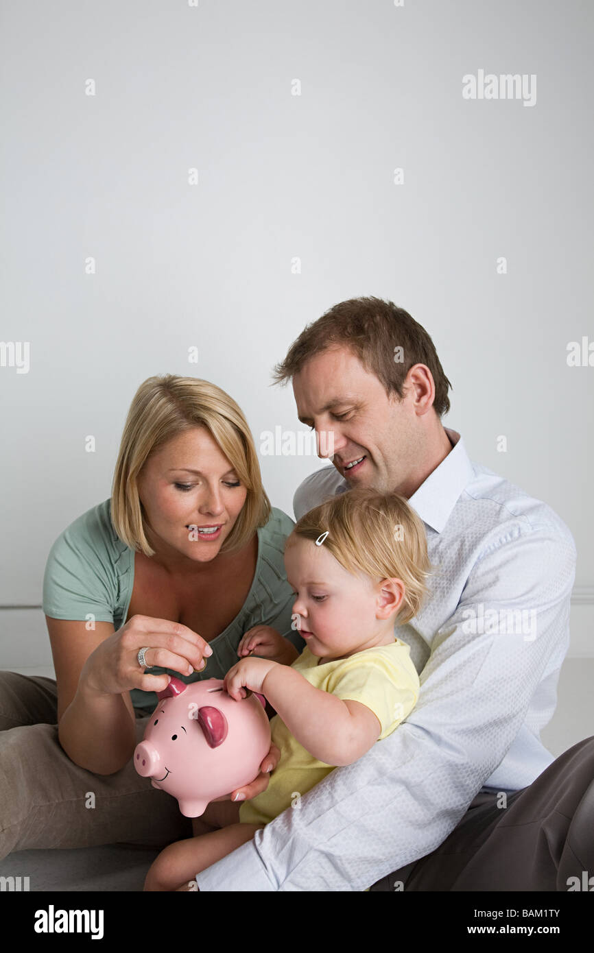 Parents and baby with piggy bank Stock Photo Alamy
