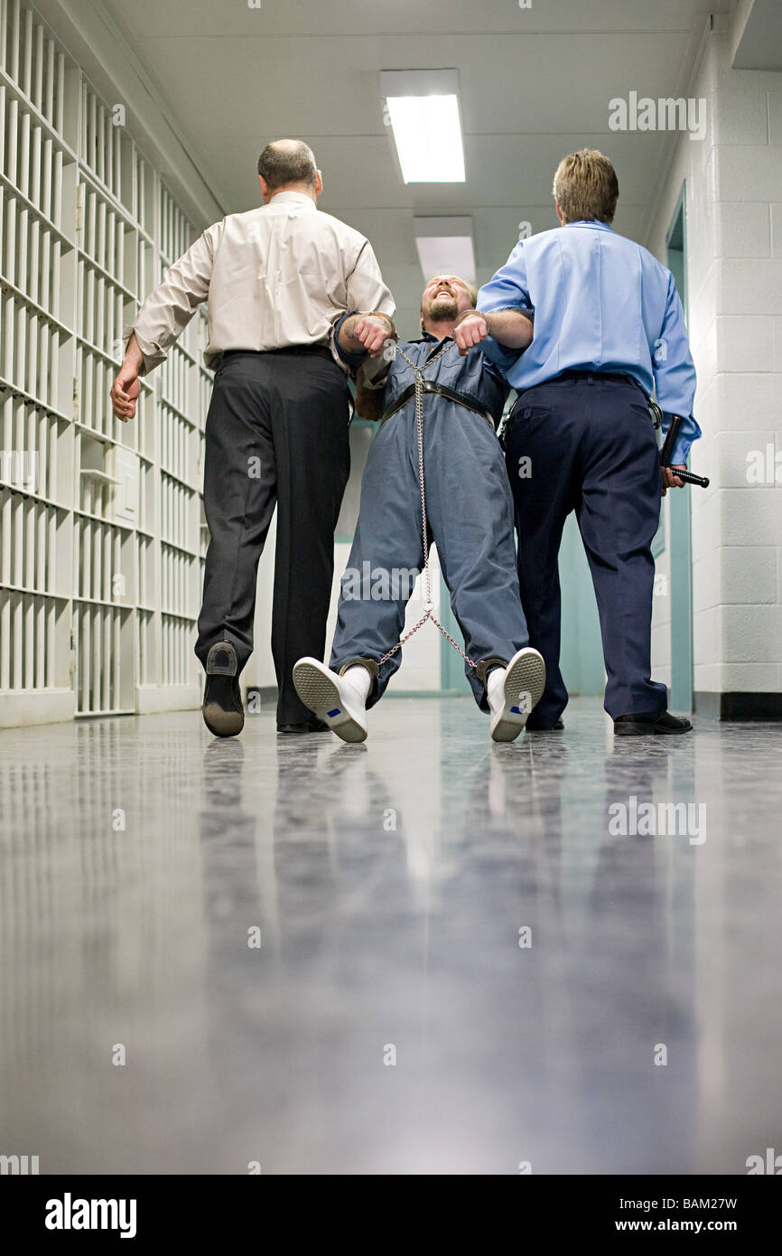 Prisoner being dragged down corridor Stock Photo
