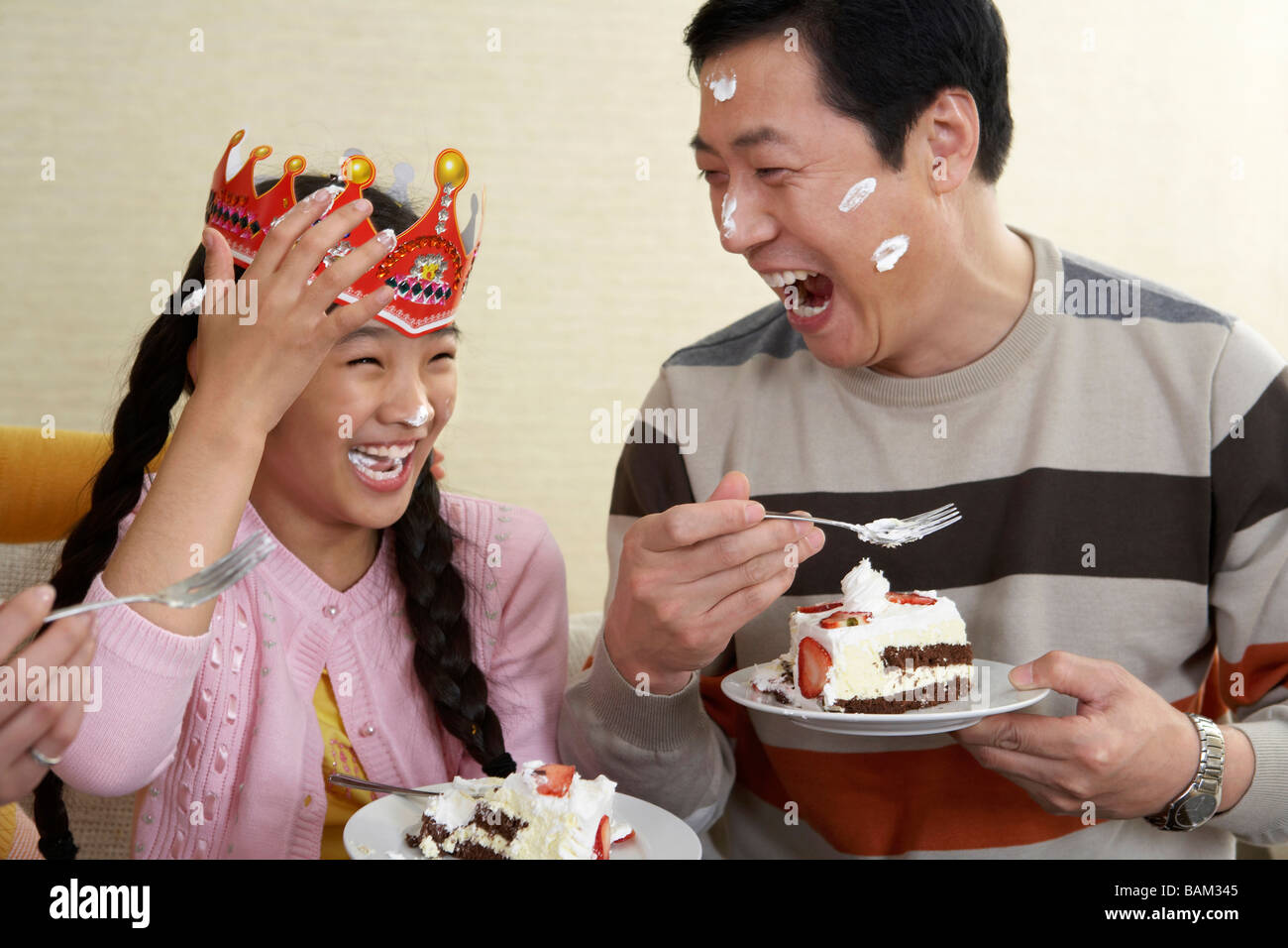 Father And Daughter Eating Birthday Cake With Cake On Their Faces