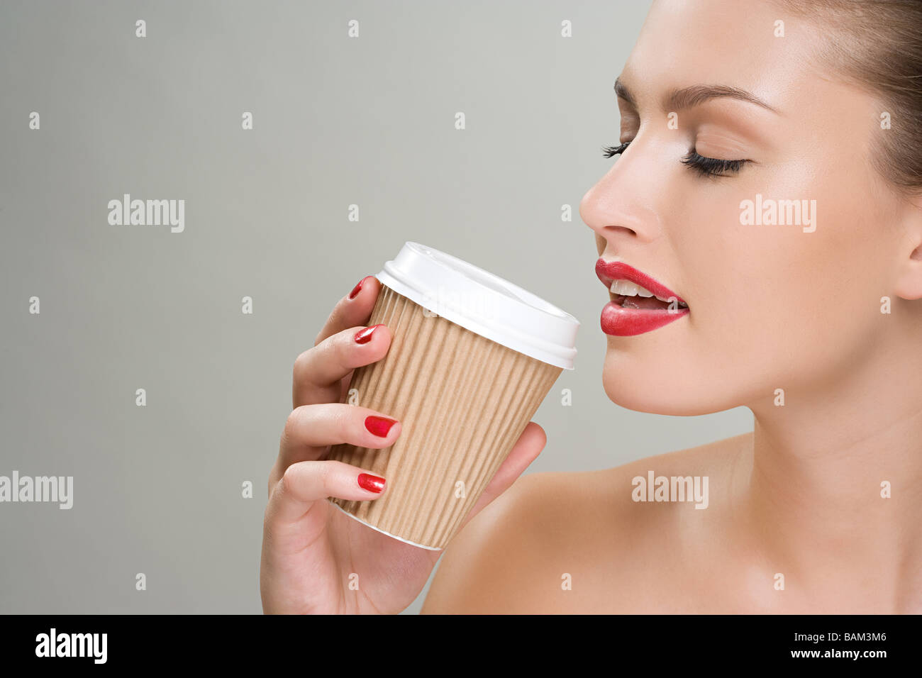 Woman drinking coffee from a paper cup Stock Photo