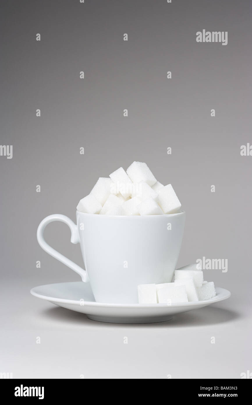 A cup full of sugar lumps Stock Photo