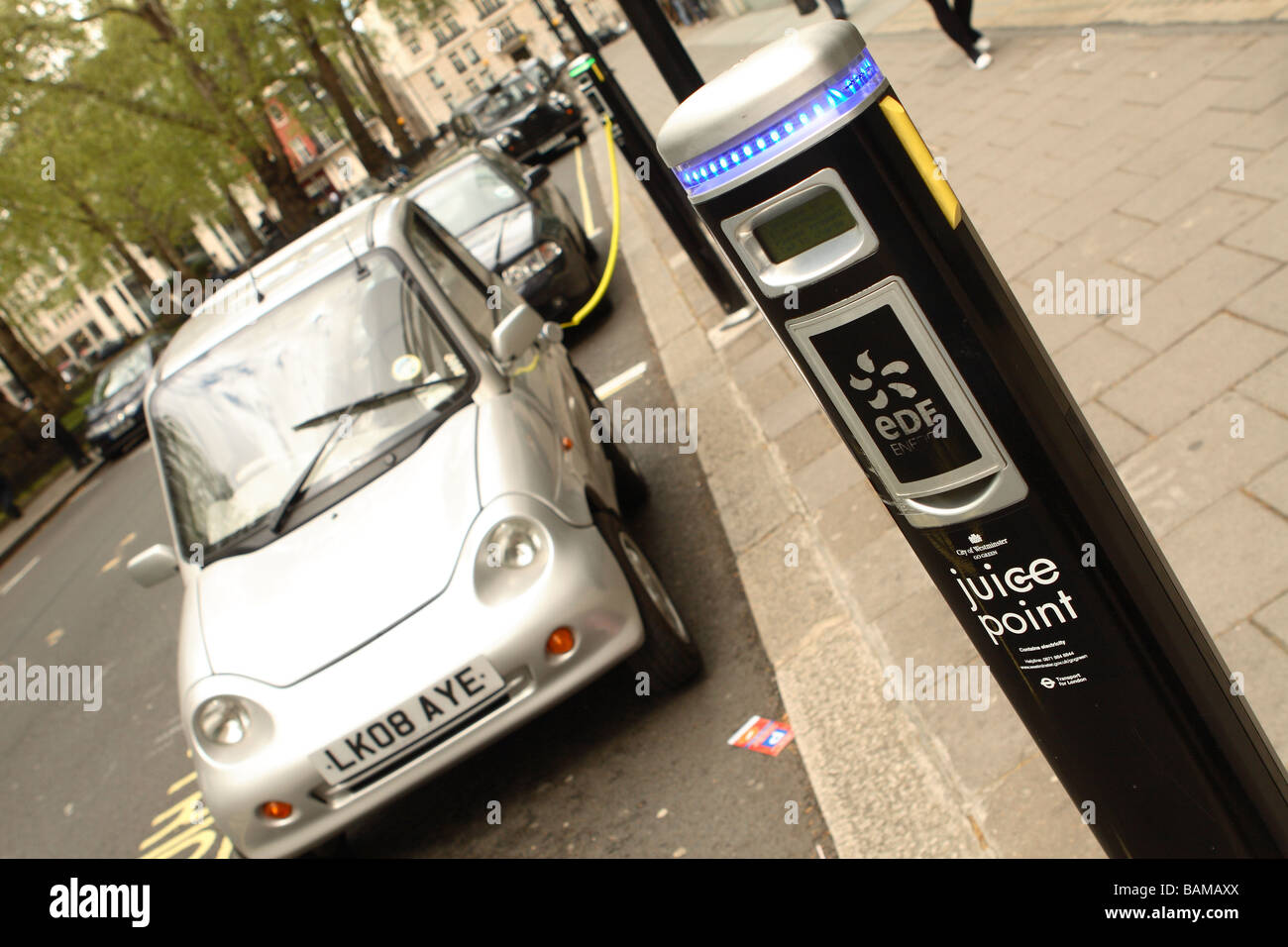 Central London GWiz G-Wiz G Wiz Electric car vehicle recharging at Juice Point providing electricity fuel power in Westminster Stock Photo