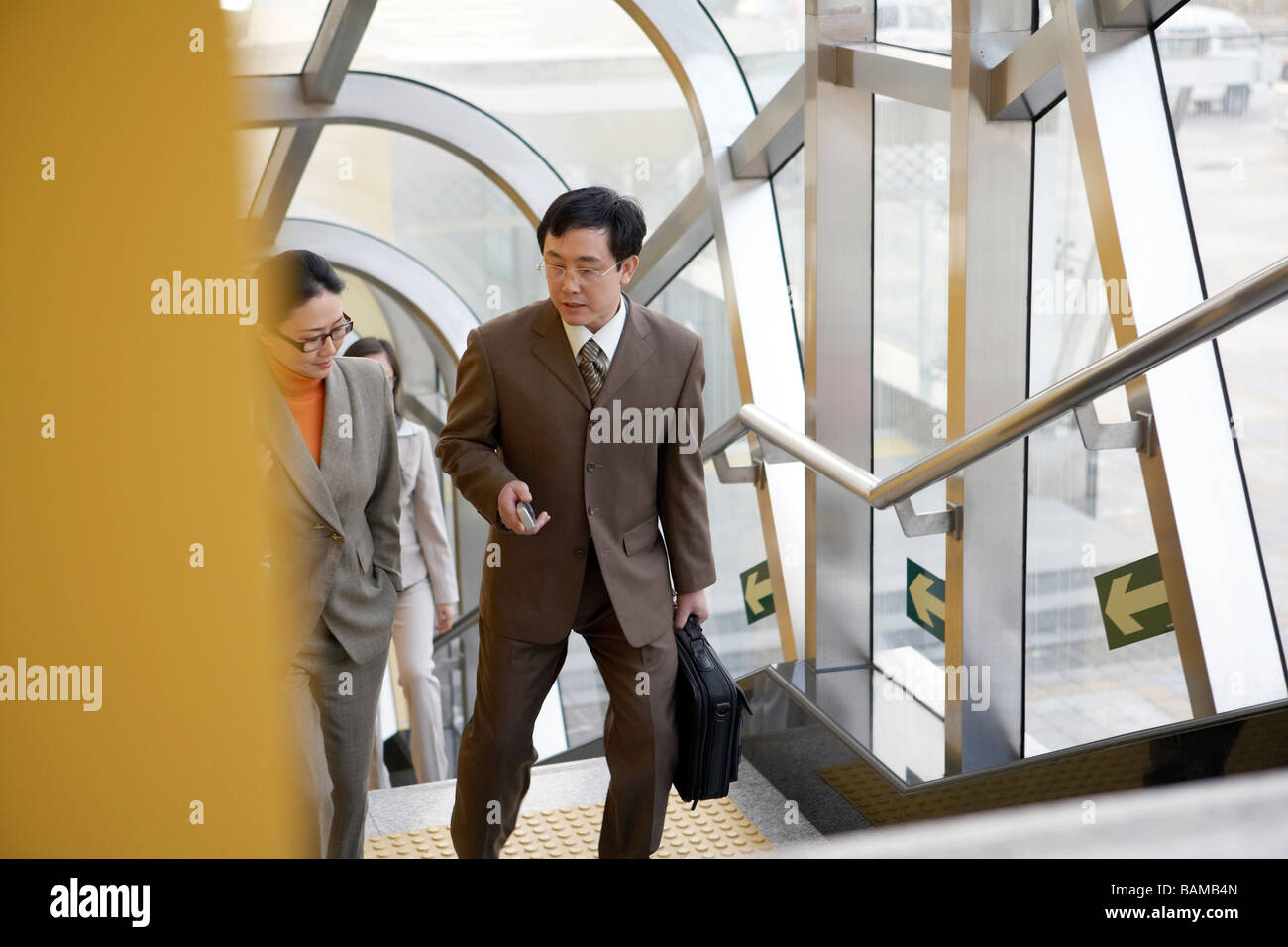 Businessman And Businesswoman Walking Up Subway Stairs Stock Photo