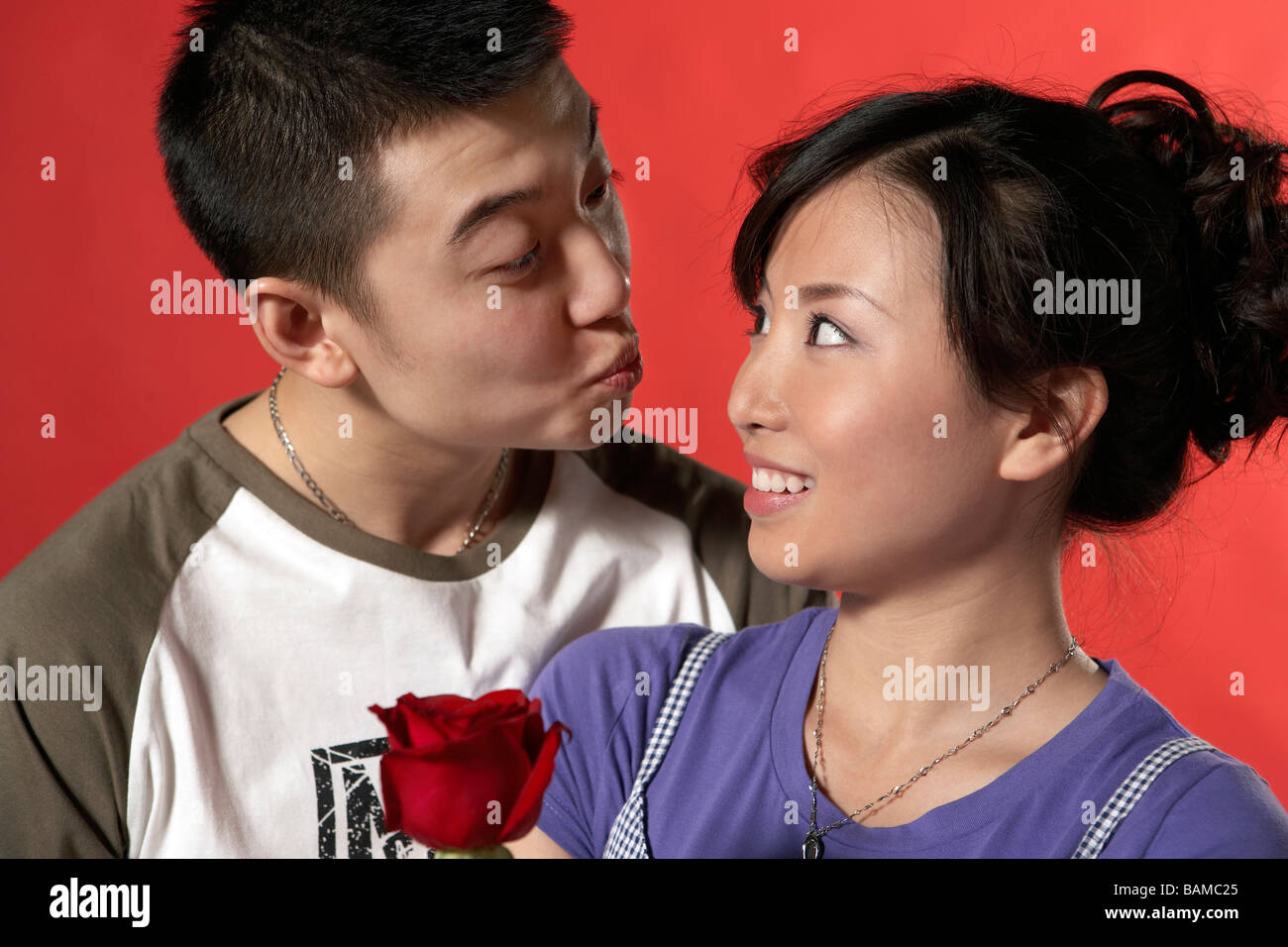 Happy Young Couple Holding Flower Stock Photo