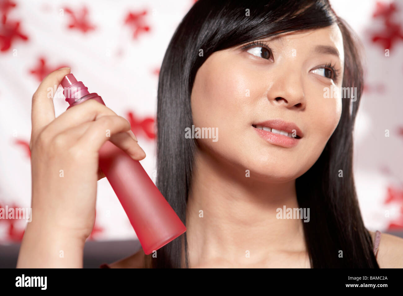 Young Women Spraying Mist on Face Stock Photo