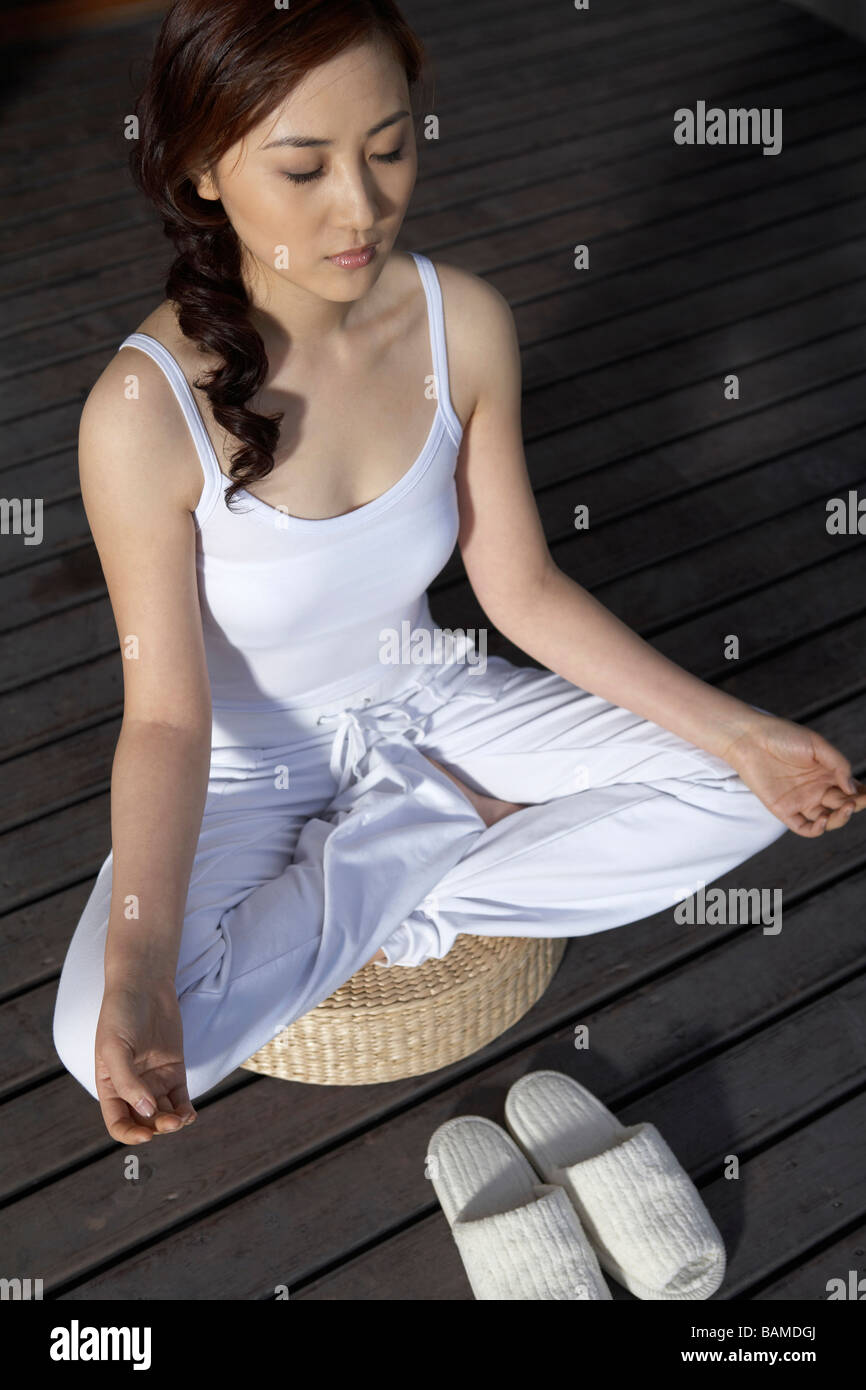 Woman Meditating On Deck Stock Photo