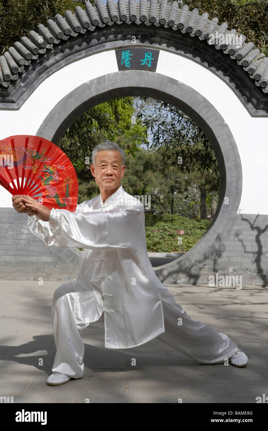 Elderly Man Practicing Martial Arts With A Fan Stock Photo Alamy