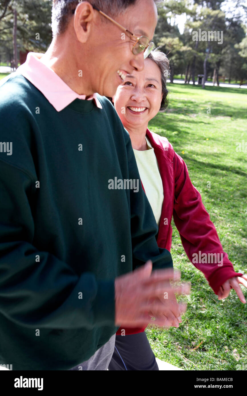 Senior Chinese Couple Walking Together Through Park Stock Photo - Alamy