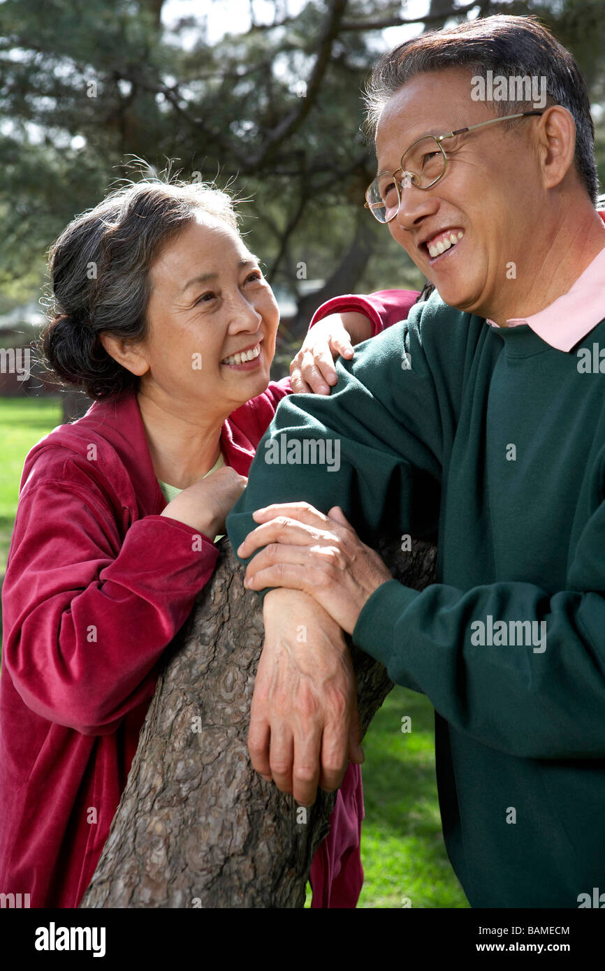 Senior Chinese Couple Leaning On Tree Branch In Park Stock Photo - Alamy