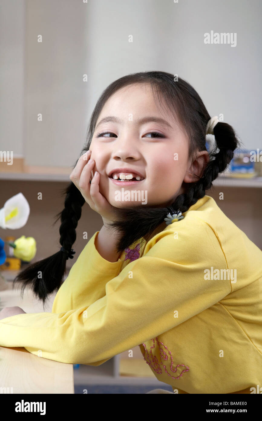 Girl Sitting With Her Hand On Her Chin Stock Photo - Alamy