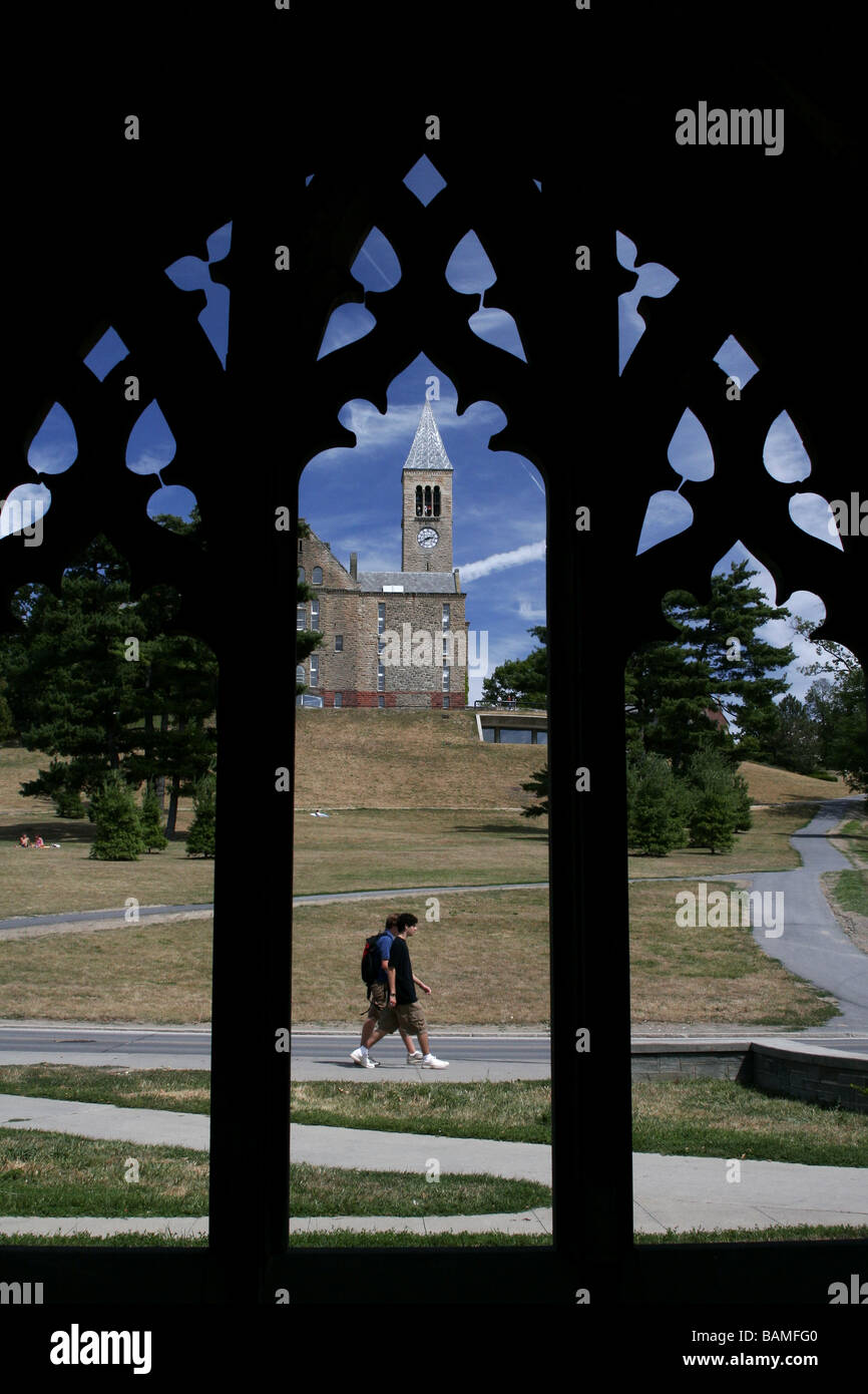 Students walk in front of the Cornell Uris Library and Clocktower, at Ithaca New York, as seen through an archway Stock Photo