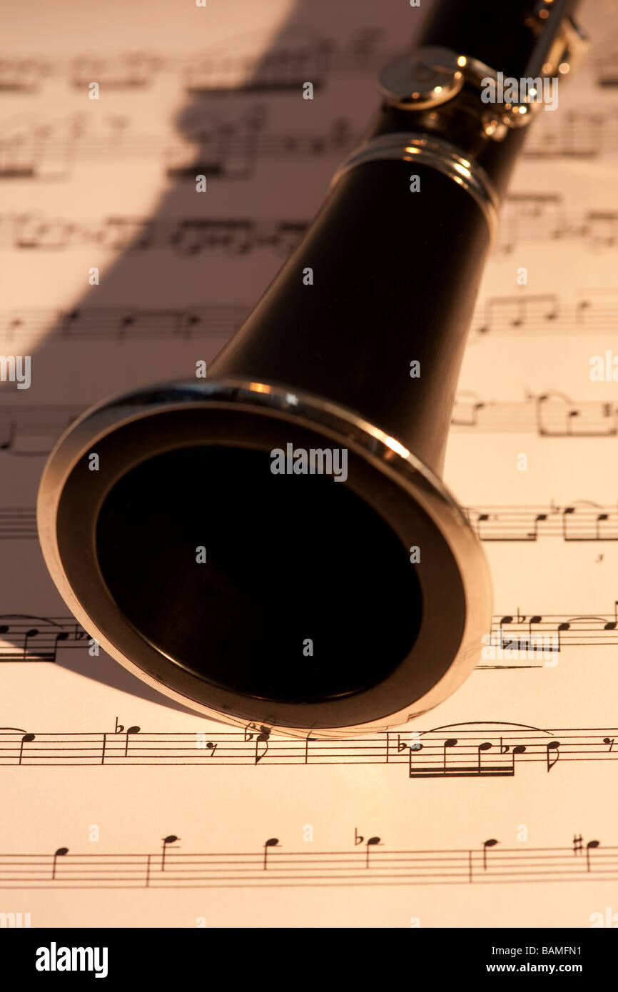 A close up of a clarinet with sheet music under it Stock Photo