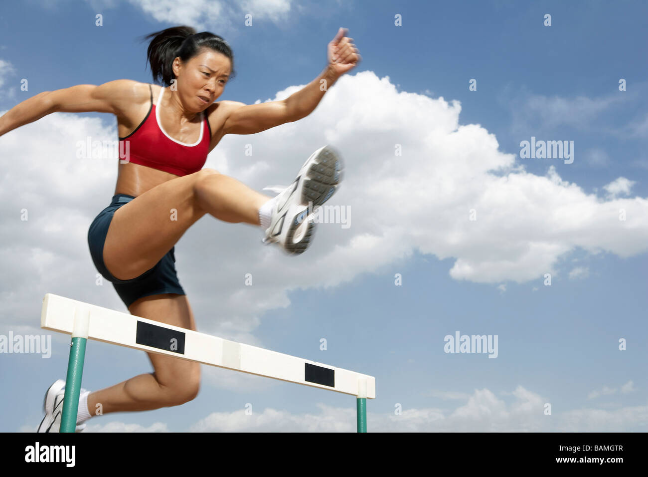 Athlete Jumping Over A Hurdle Stock Photo Alamy