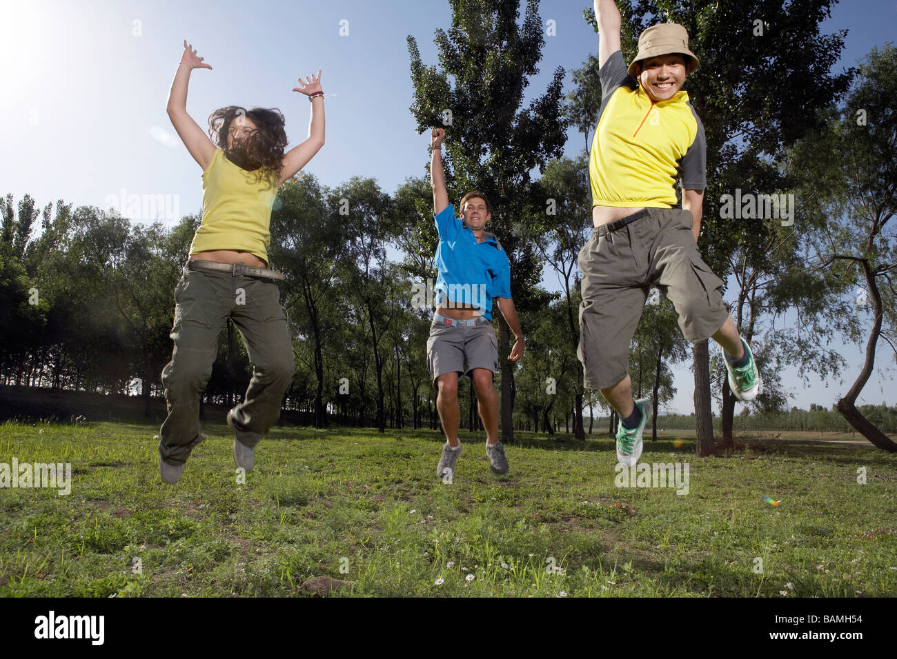 Young Adults Jumping In The Park Cheering Stock Photo - Alamy