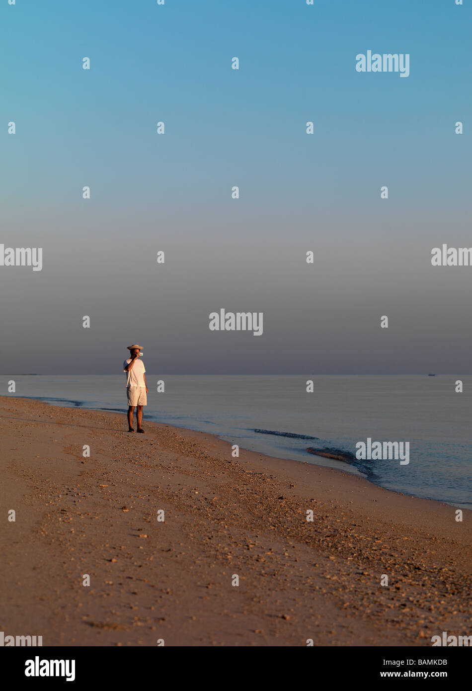 A man walks on the beach of the Java Sea in Lombok Indonesia. Stock Photo