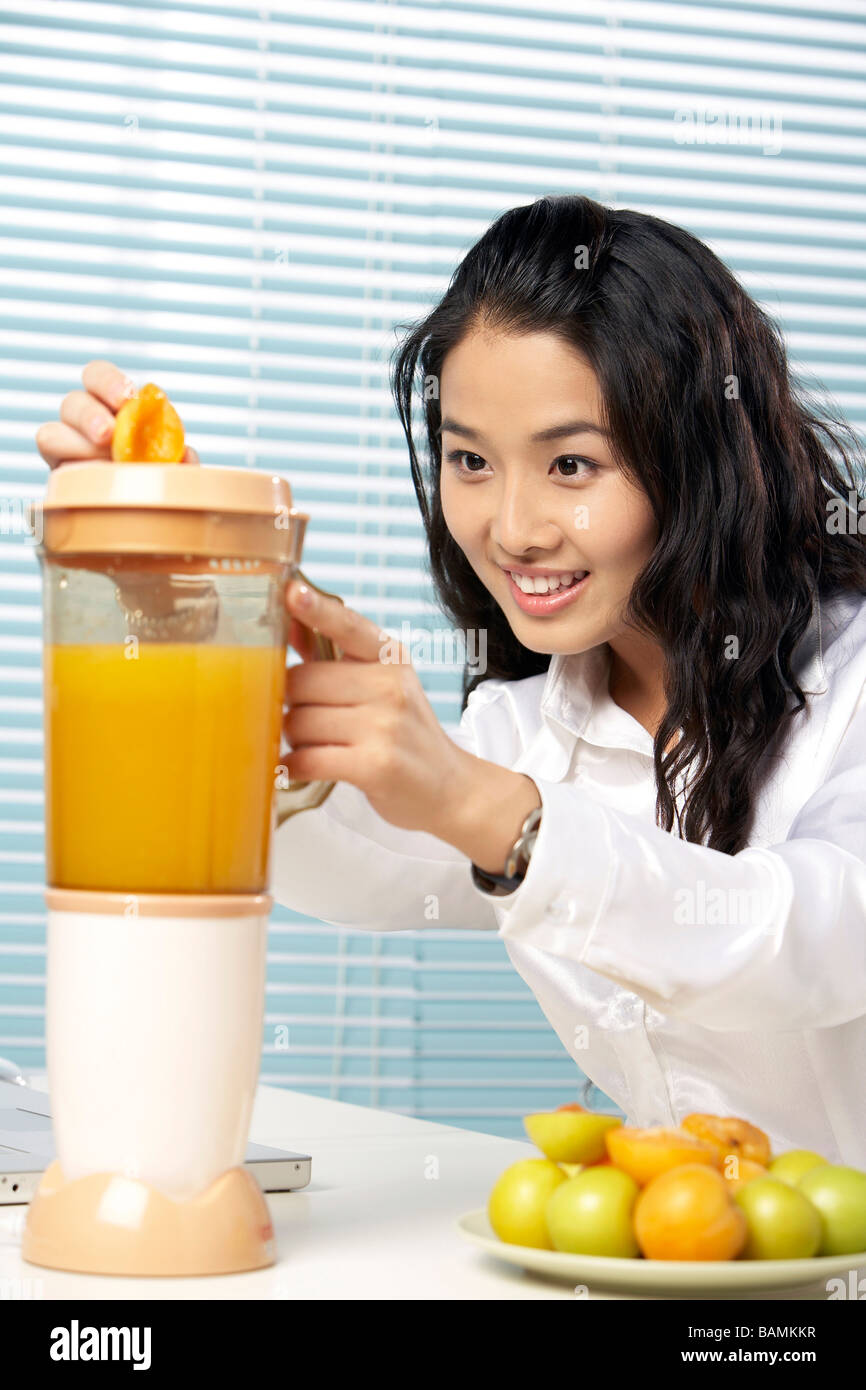Young Woman Making Fruit Juice With A Blender Stock Photo Alamy