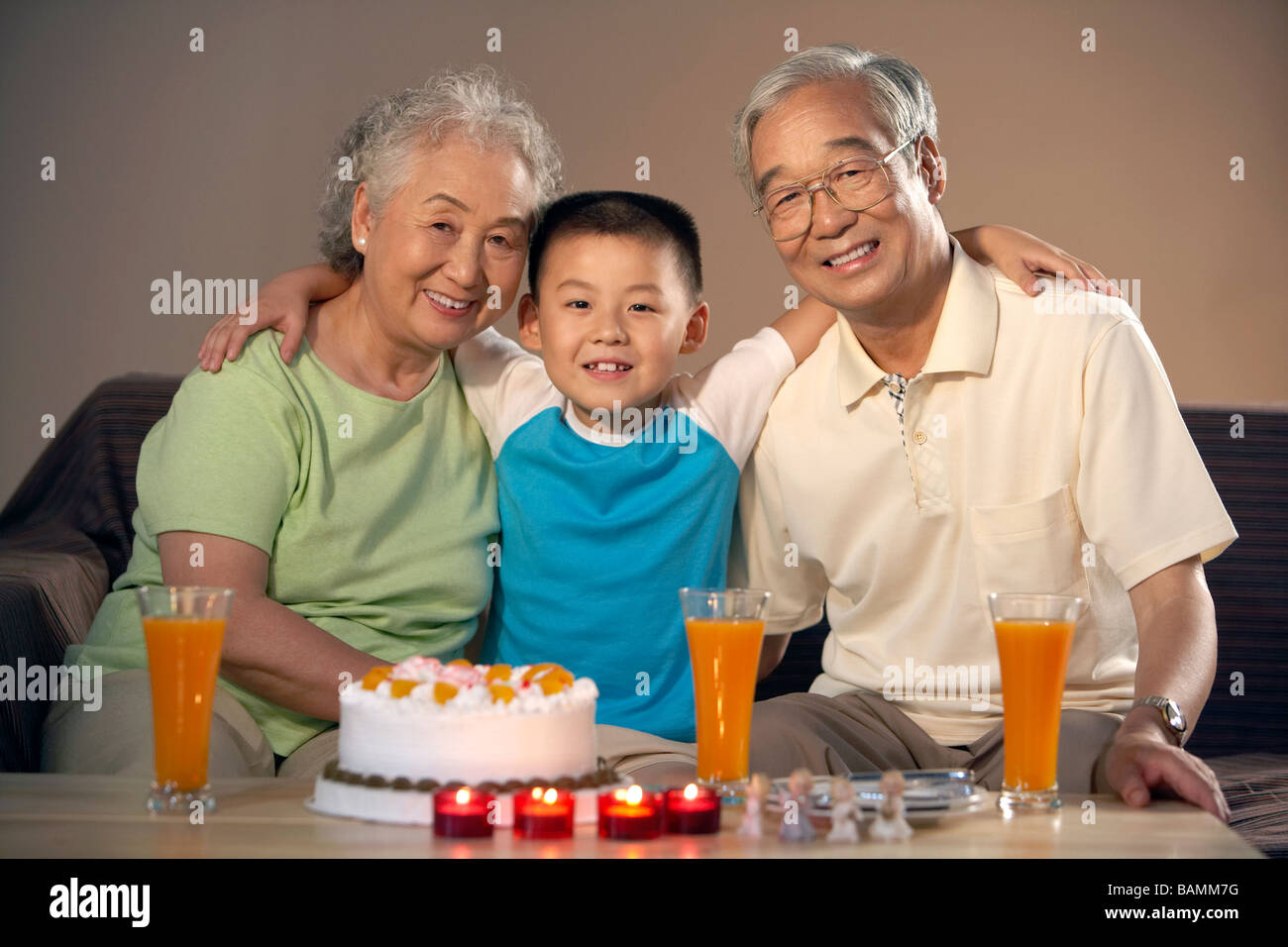 Grandparents And Their Grandson Celebrate A Birthday Stock Photo