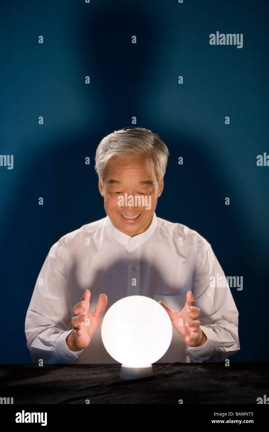 Older Businessman Looking Into Crystal Ball Stock Photo - Alamy