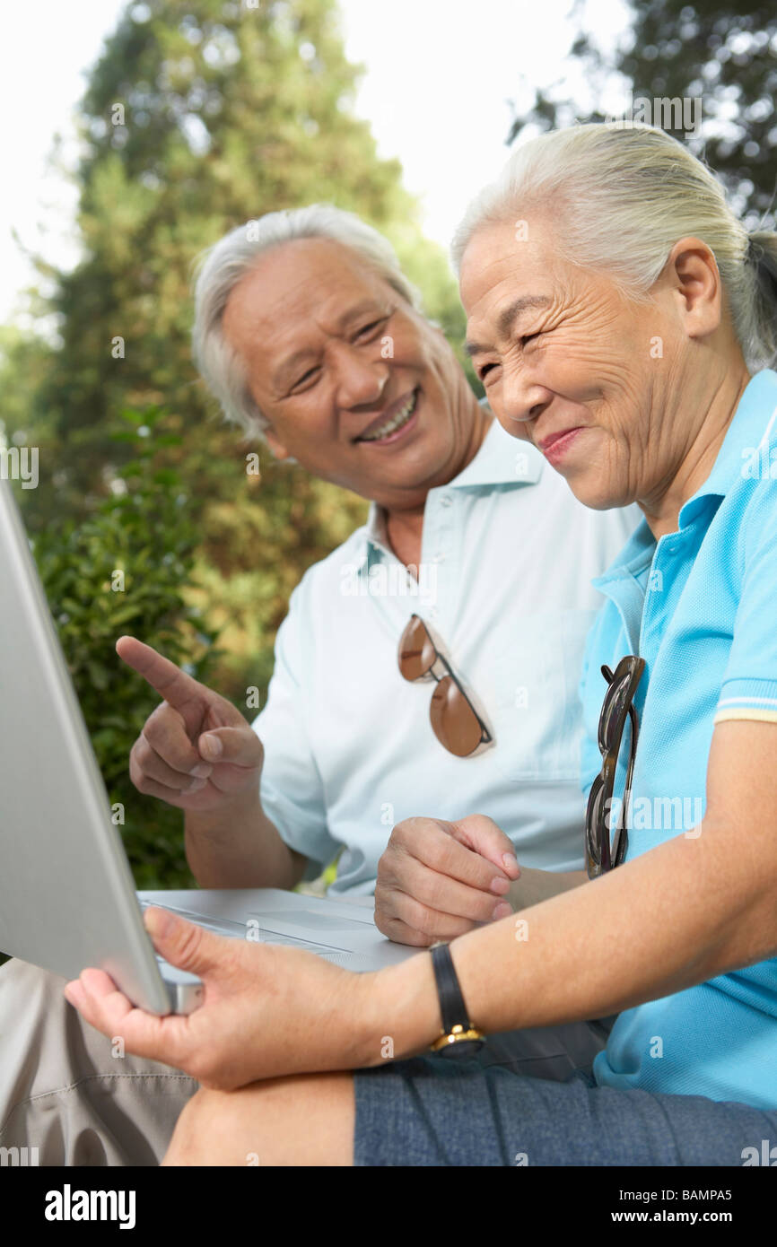 Older Couple Looking At Laptop Together Stock Photo