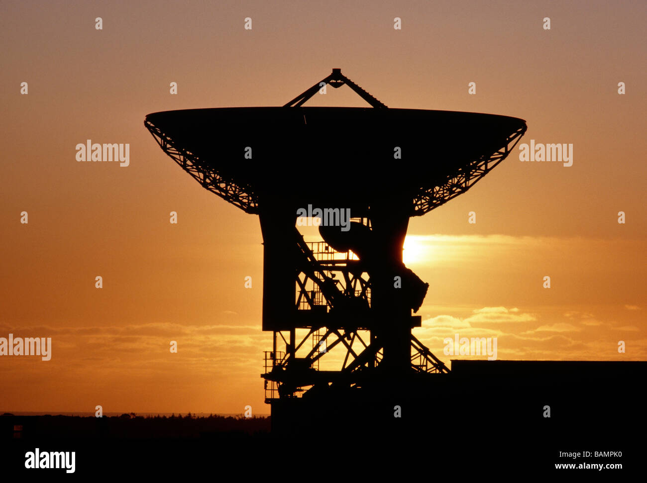 TELECOMMUNICATIONS SATELLITE DISH SILHOUTTED AGAINST AN ORANGE SUNSET SKY CORNWALL ENGLAND Stock Photo