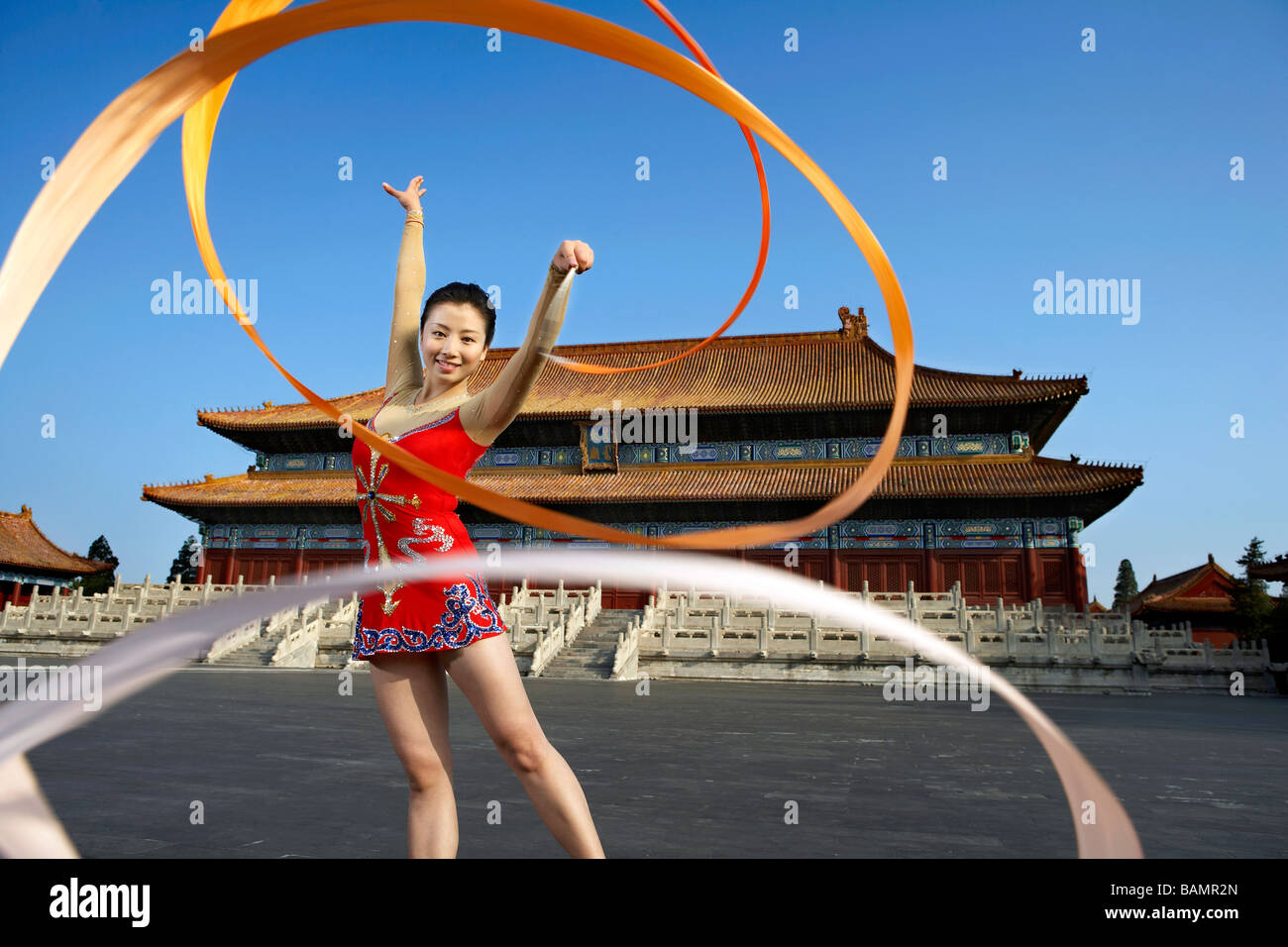 Young Woman Ribbon Dancing In Front Of A Temple Stock Photo