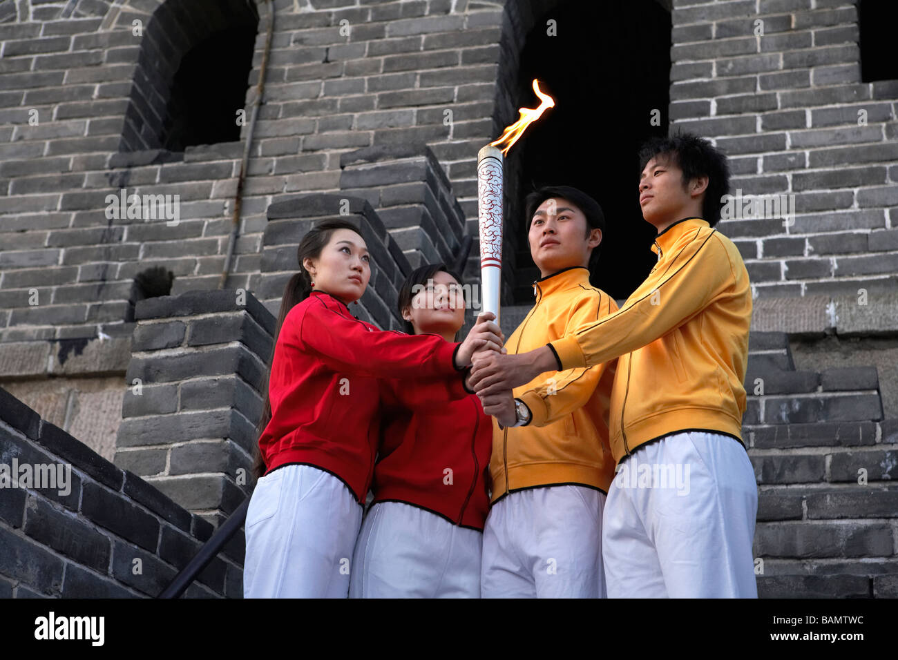 Two Young Couples Perform The Passing Of The Torch Ceremony At The UNESCO World Heritage Site Stock Photo