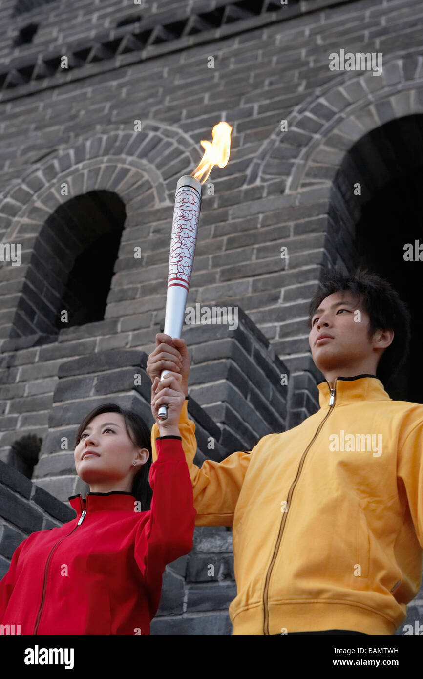 Two Young Couples Perform The Passing Of The Torch Ceremony At The UNESCO World Heritage Site Stock Photo