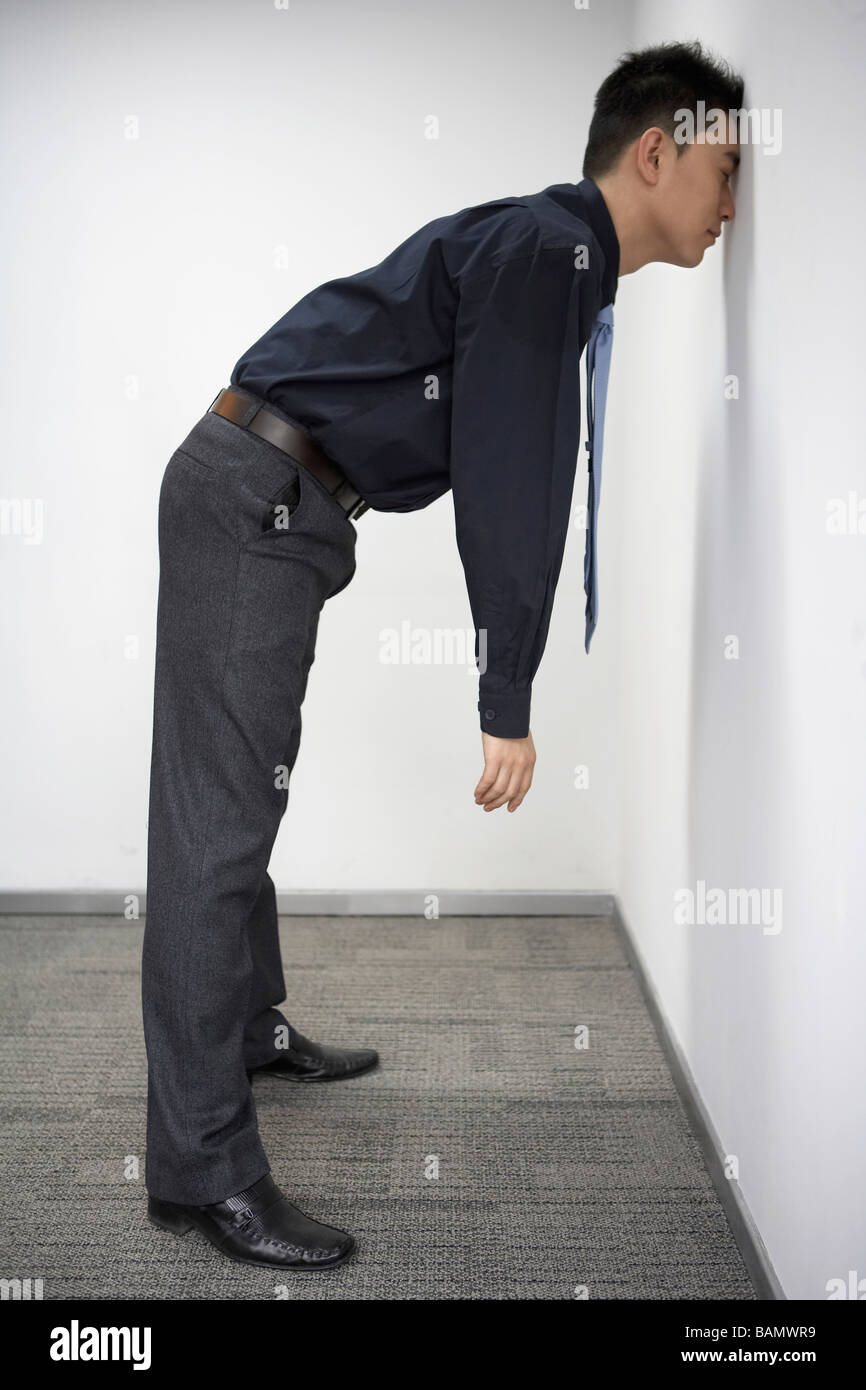 Businessman Resting Face Against Wall Stock Photo