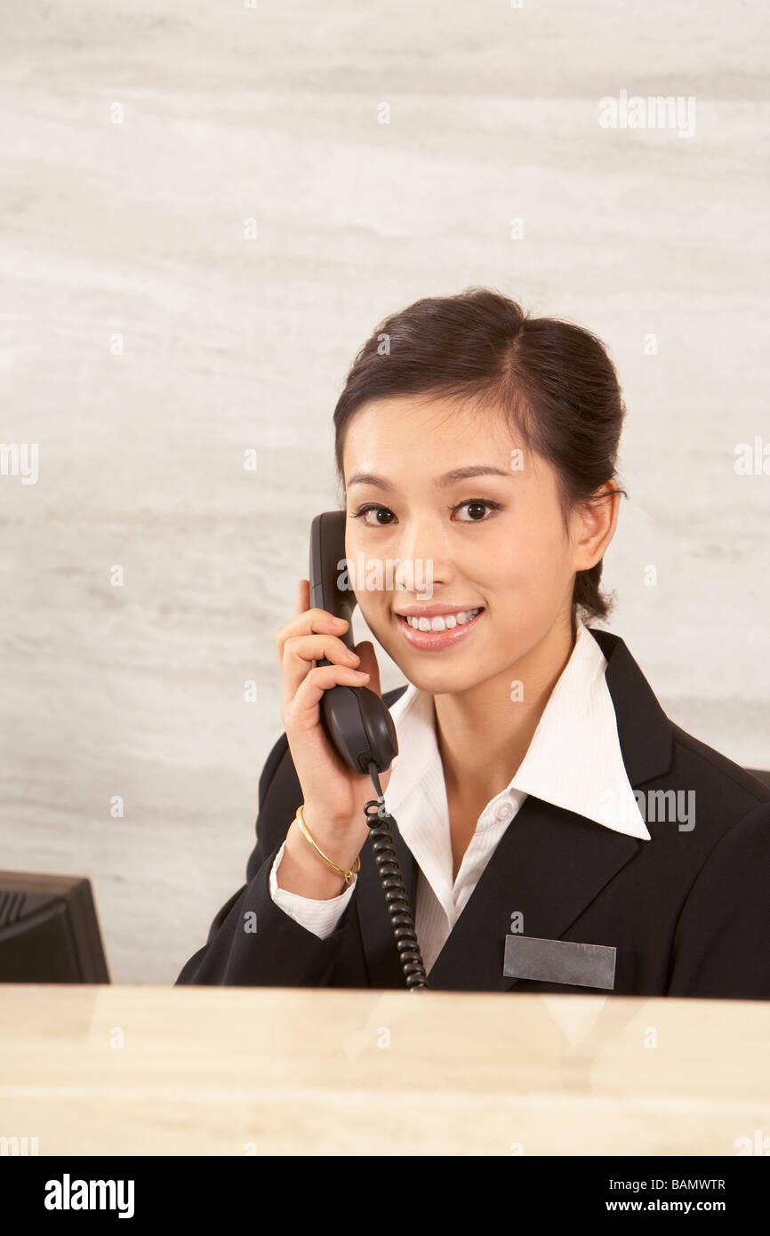 Young Receptionist On Telephone At Front Desk Stock Photo Alamy