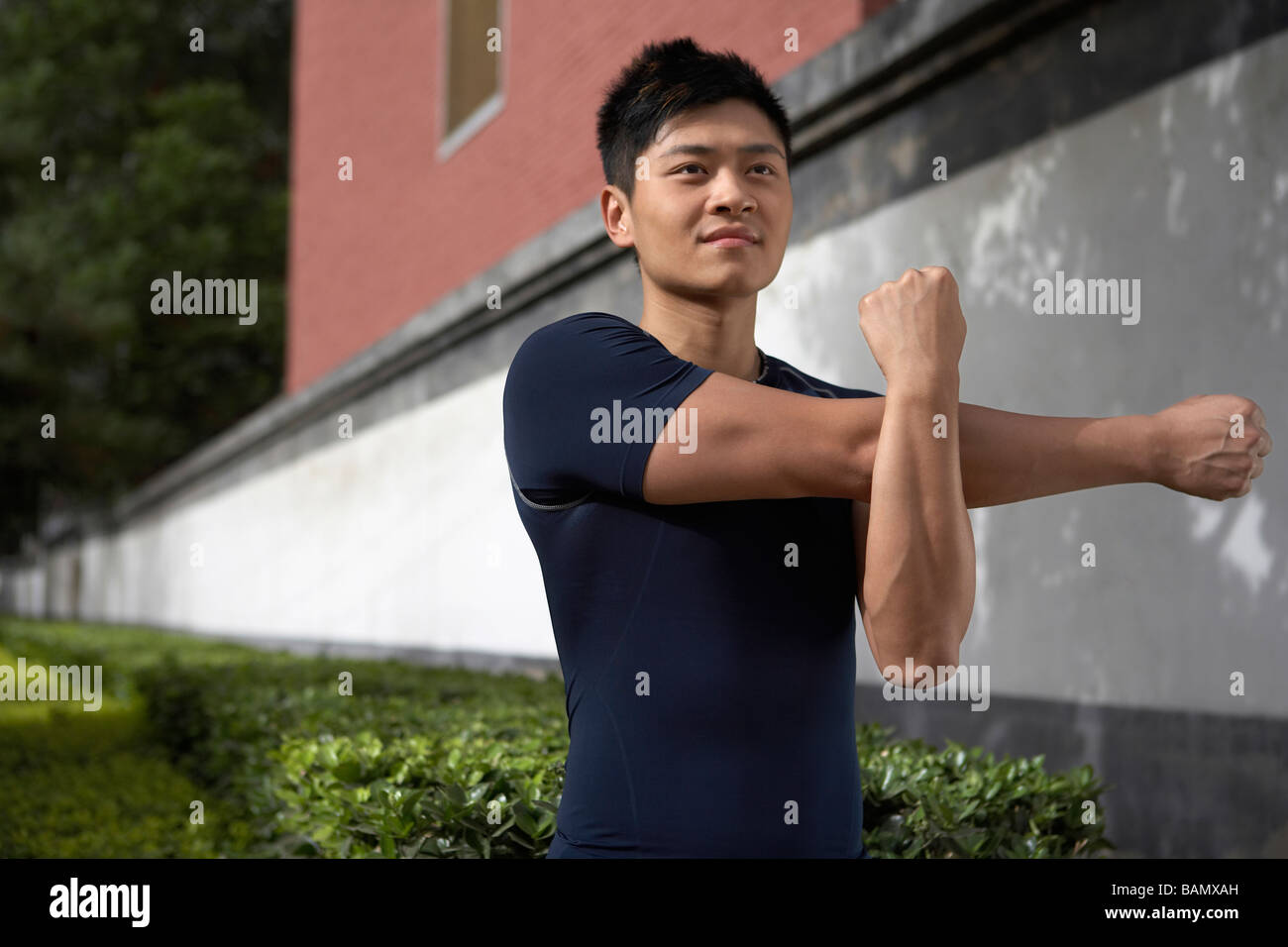 Young man stretching arm muscles hi-res stock photography and images ...