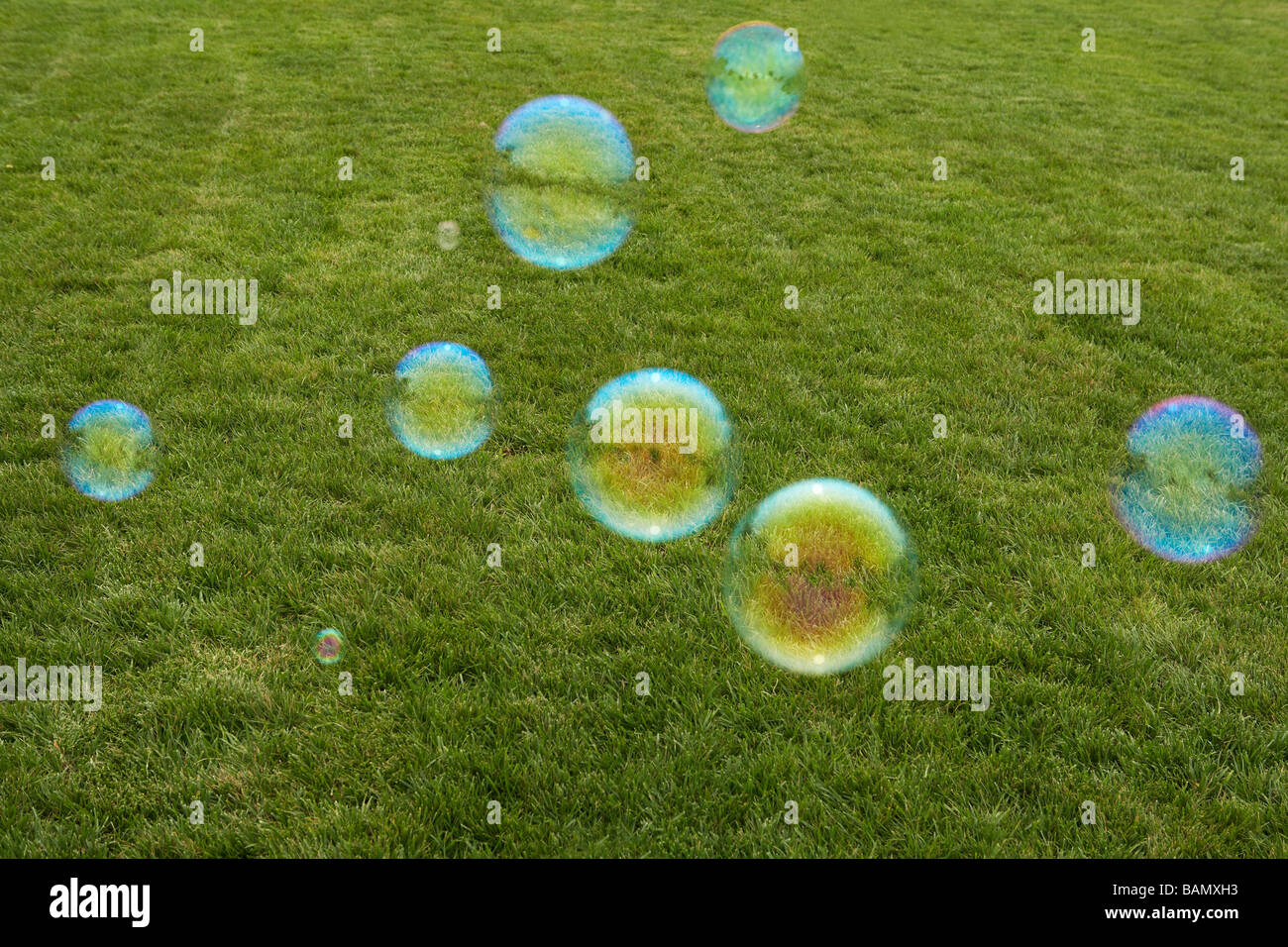 Young Girl Chasing Bubbles In Park Stock Photo