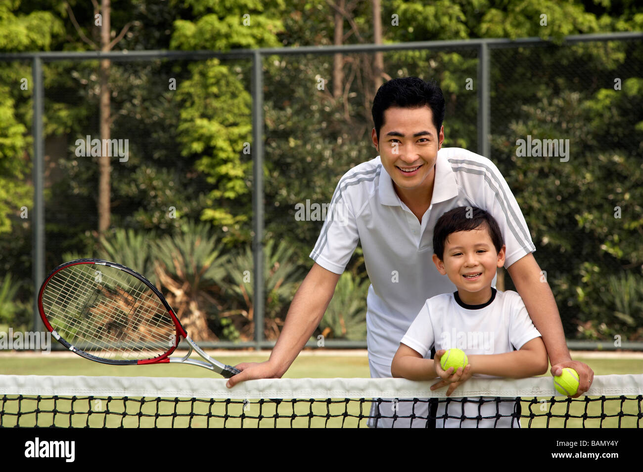 Father and son on the tennis court Stock Photo Alamy