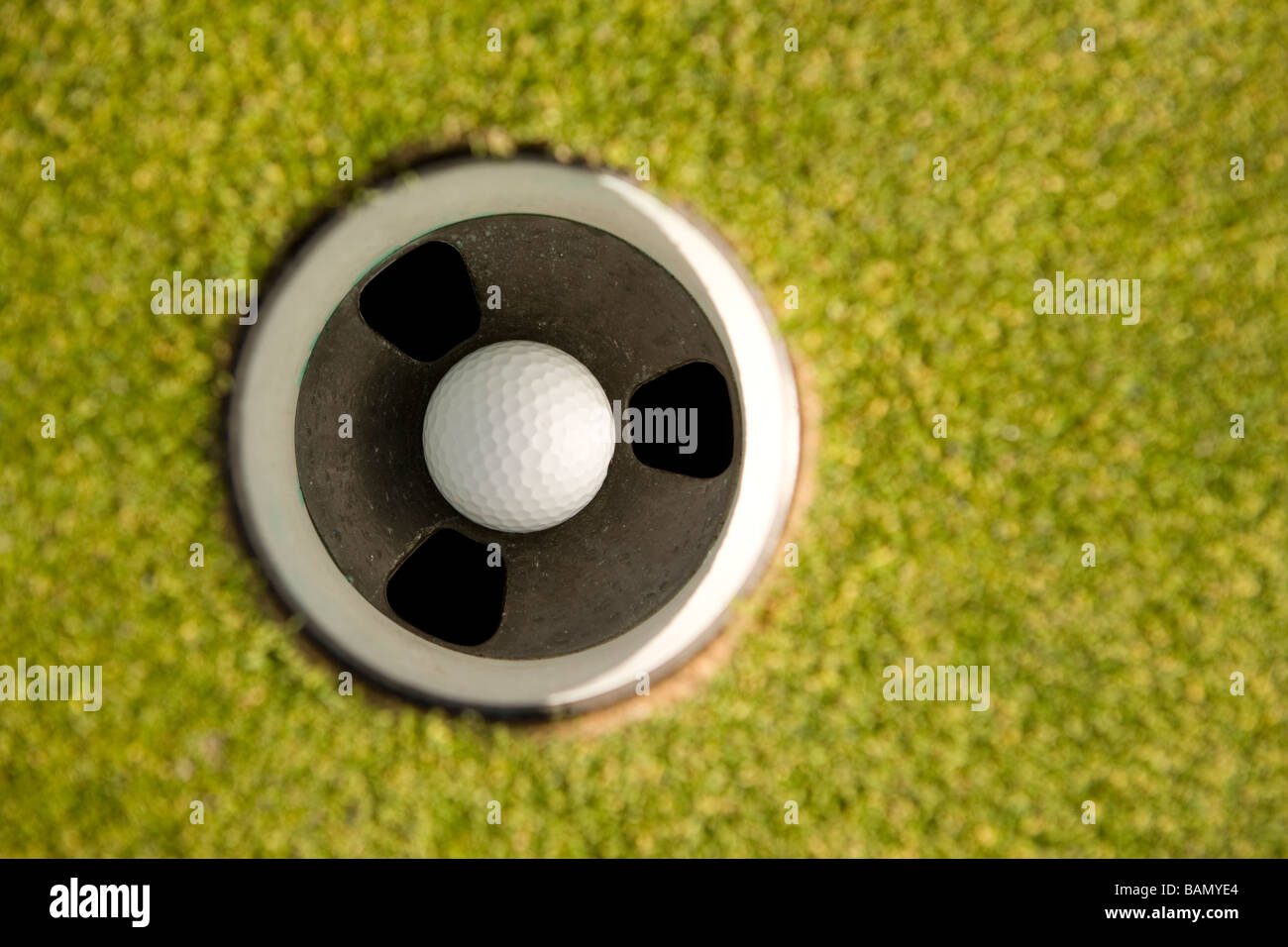 Golf ball in hole Stock Photo Alamy