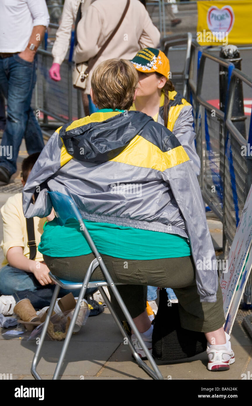 A fat woman sitting on a folding chair at London Marathon 2009, England, UK Stock Photo