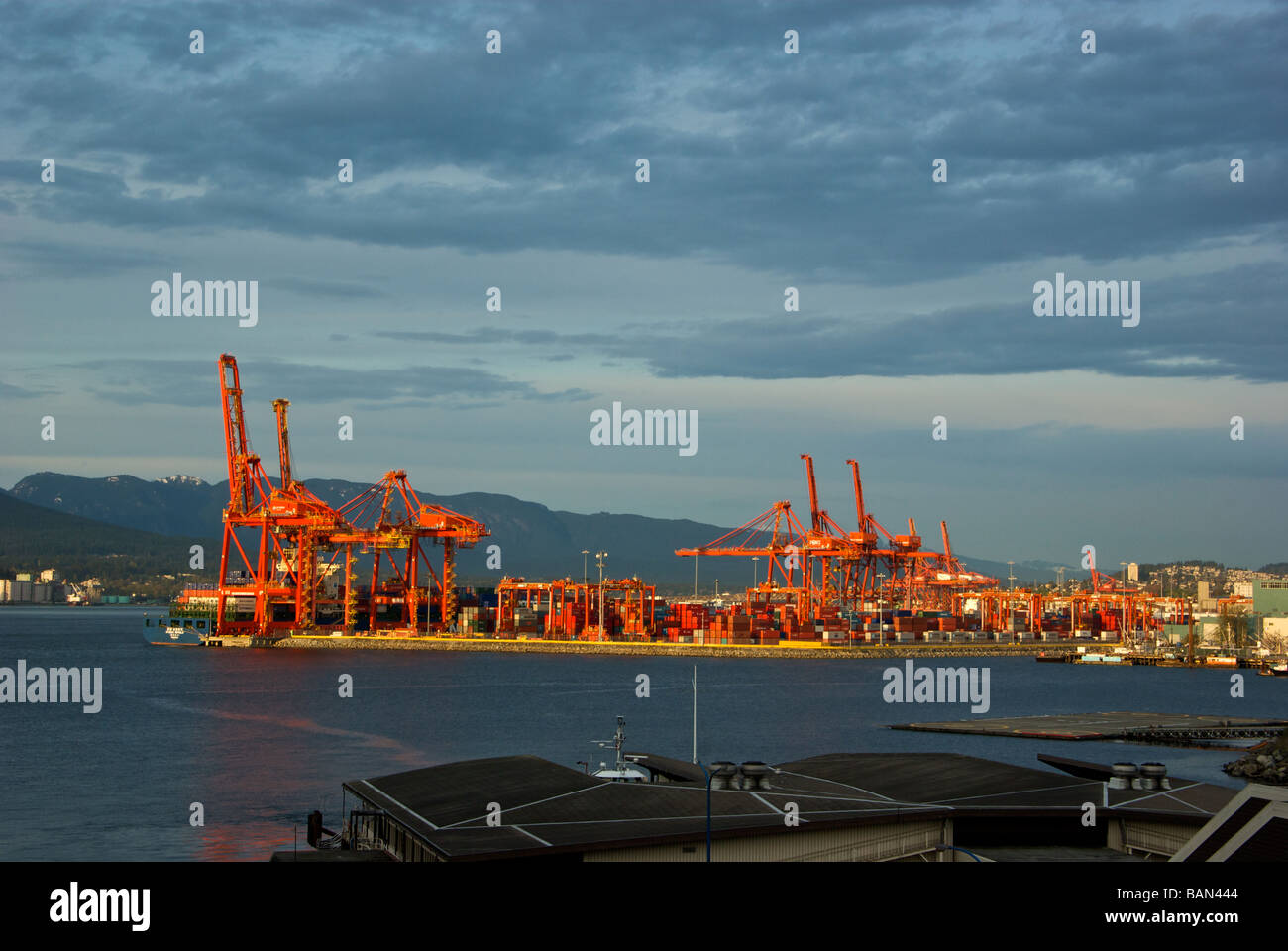 Centerm container port terminal in Vancouver harbour glow orange in the warm setting sun Stock Photo