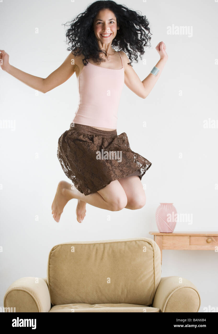 Young woman jumping on the couch Stock Photo Alamy
