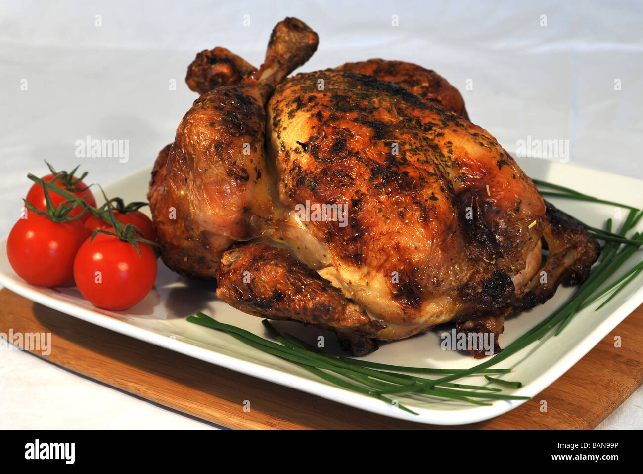 Roast chicken served on a white plate with vegetable decoration. Stock Photo
