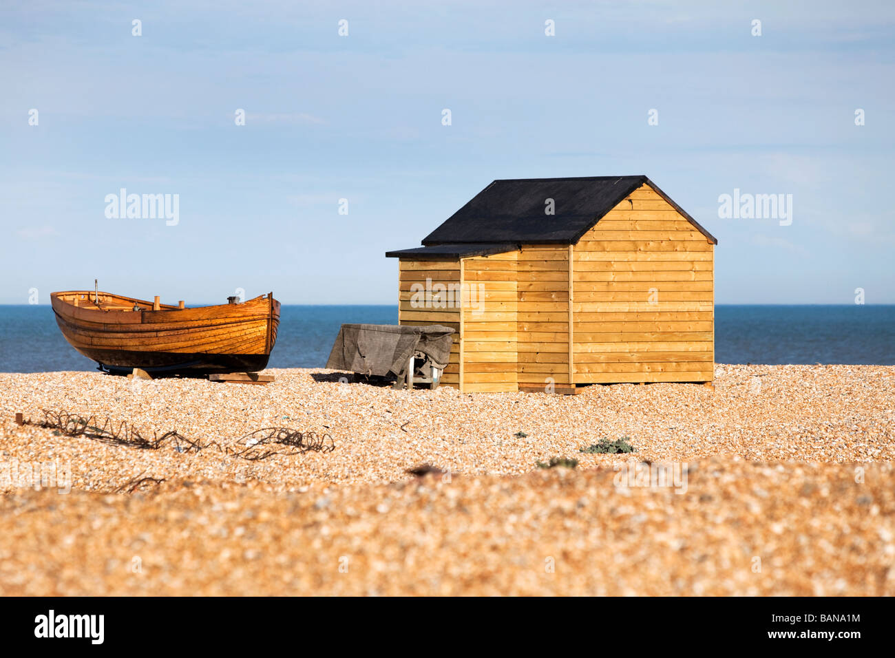 Traditional clinker built fishing boat and beach hut on England's South East, Channel coast Stock Photo