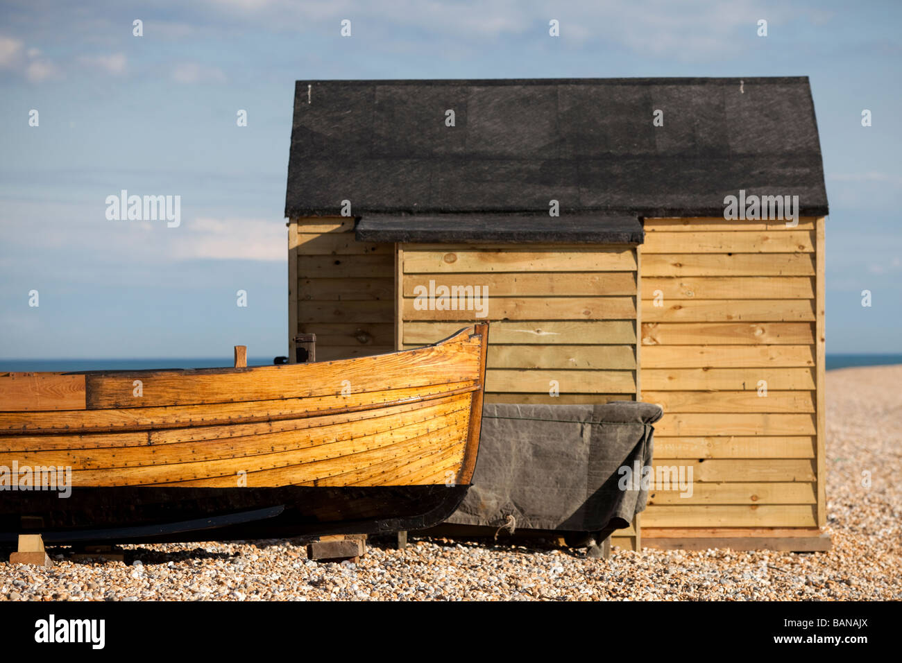 Traditional Clinker Built Fishing Boat And Beach Hut On England S