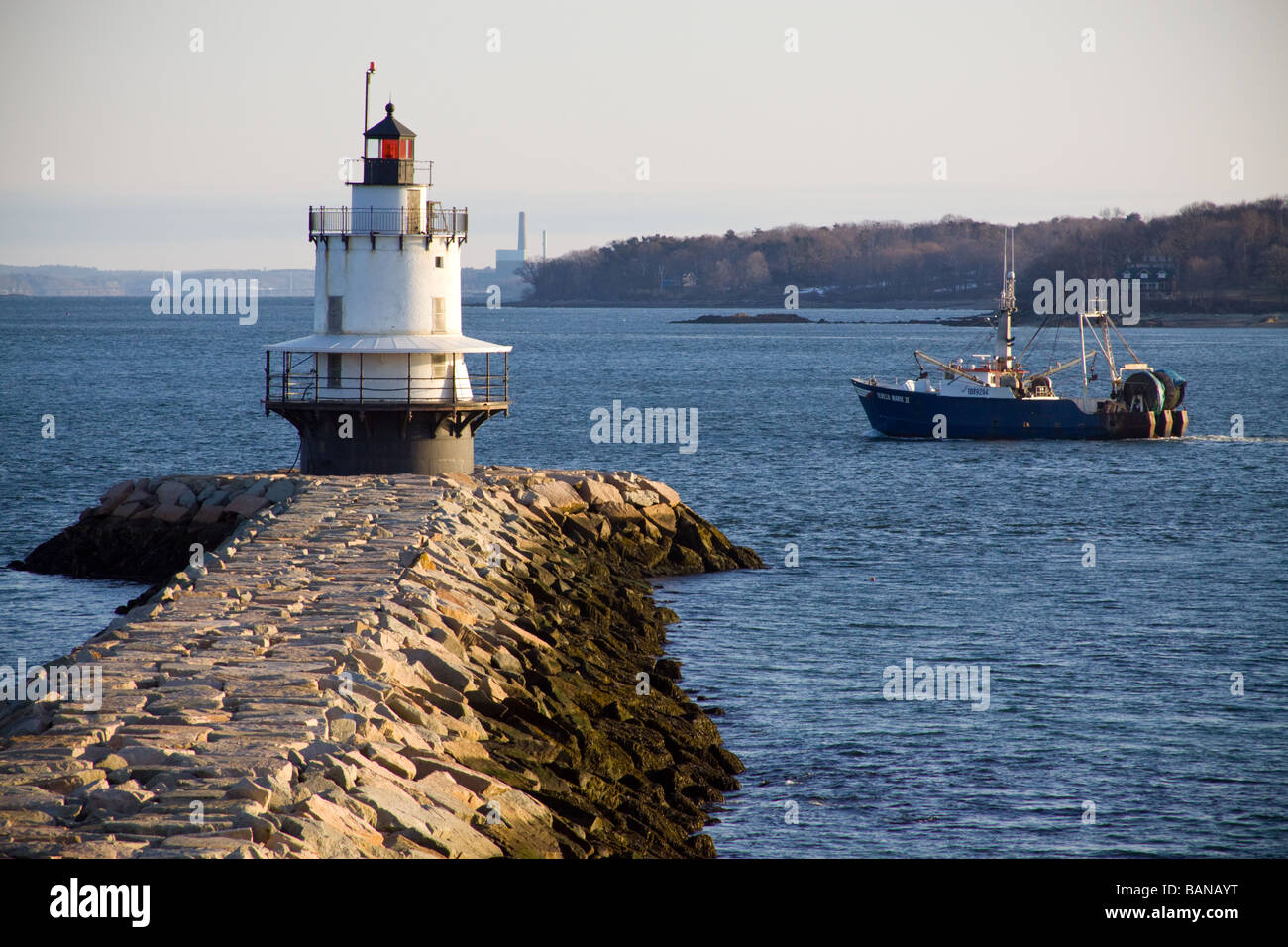 Morning sun reflects off Spring Point Light as a local fishing boat passes by, South Portland, Maine,USA. Stock Photo