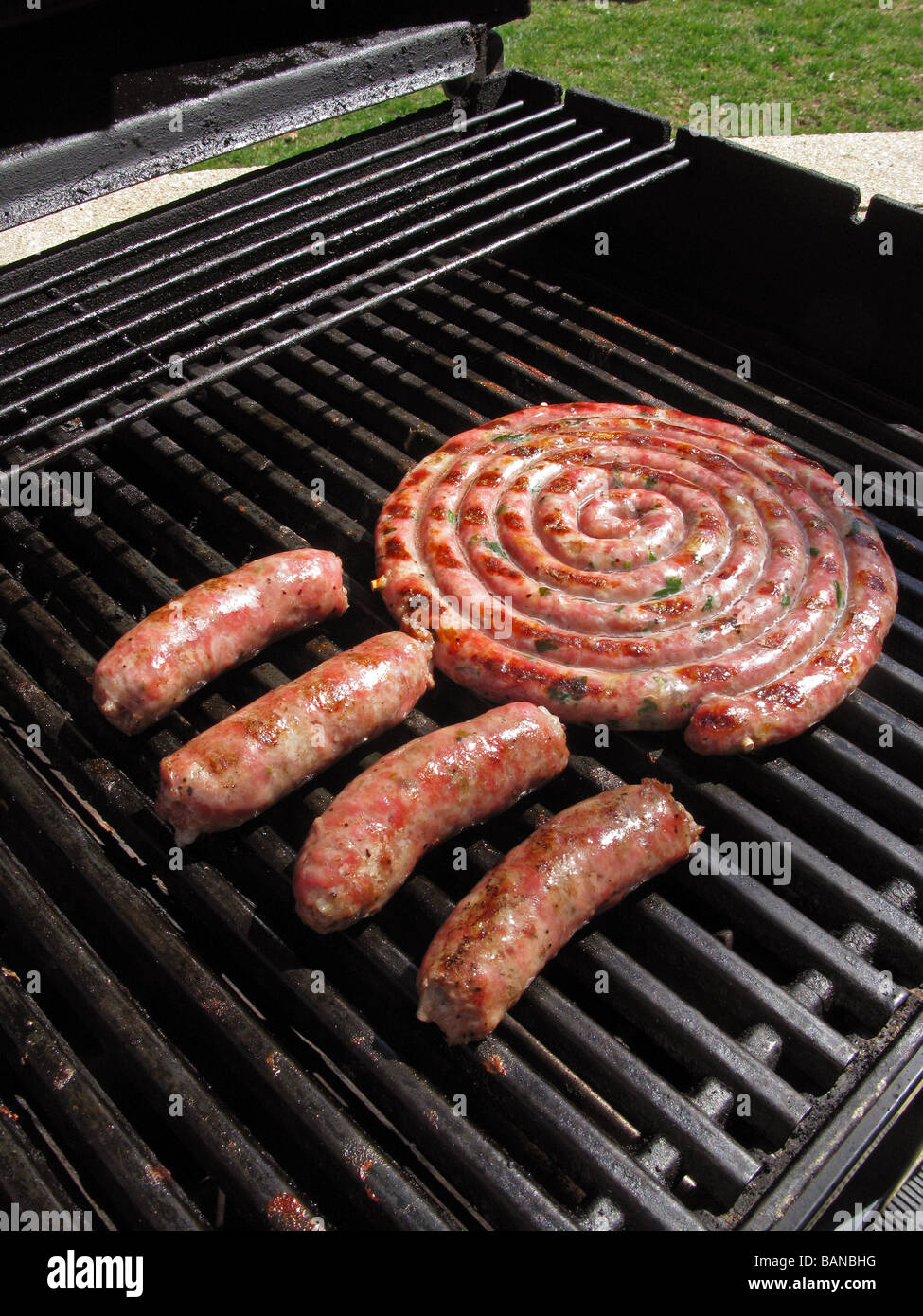 sausages grilling on an outdoor grill Stock Photo Alamy
