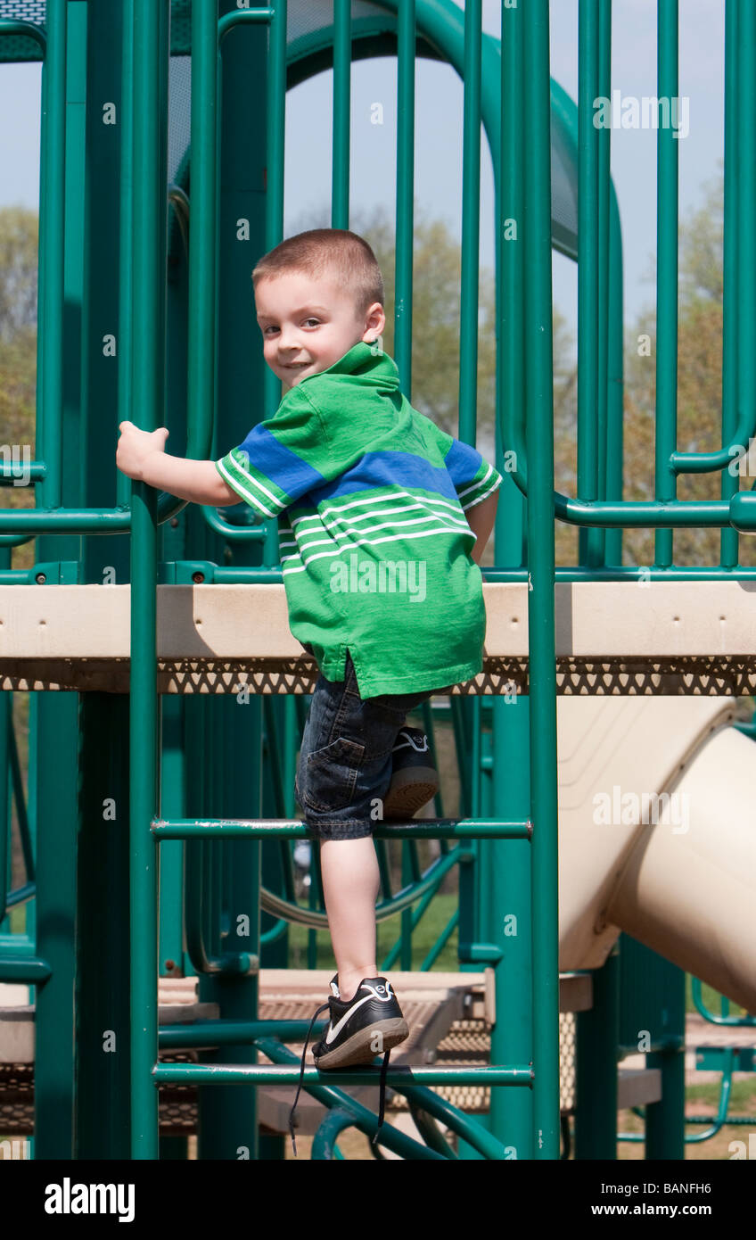 A young child climbing climbing on a playground playset Stock Photo Alamy