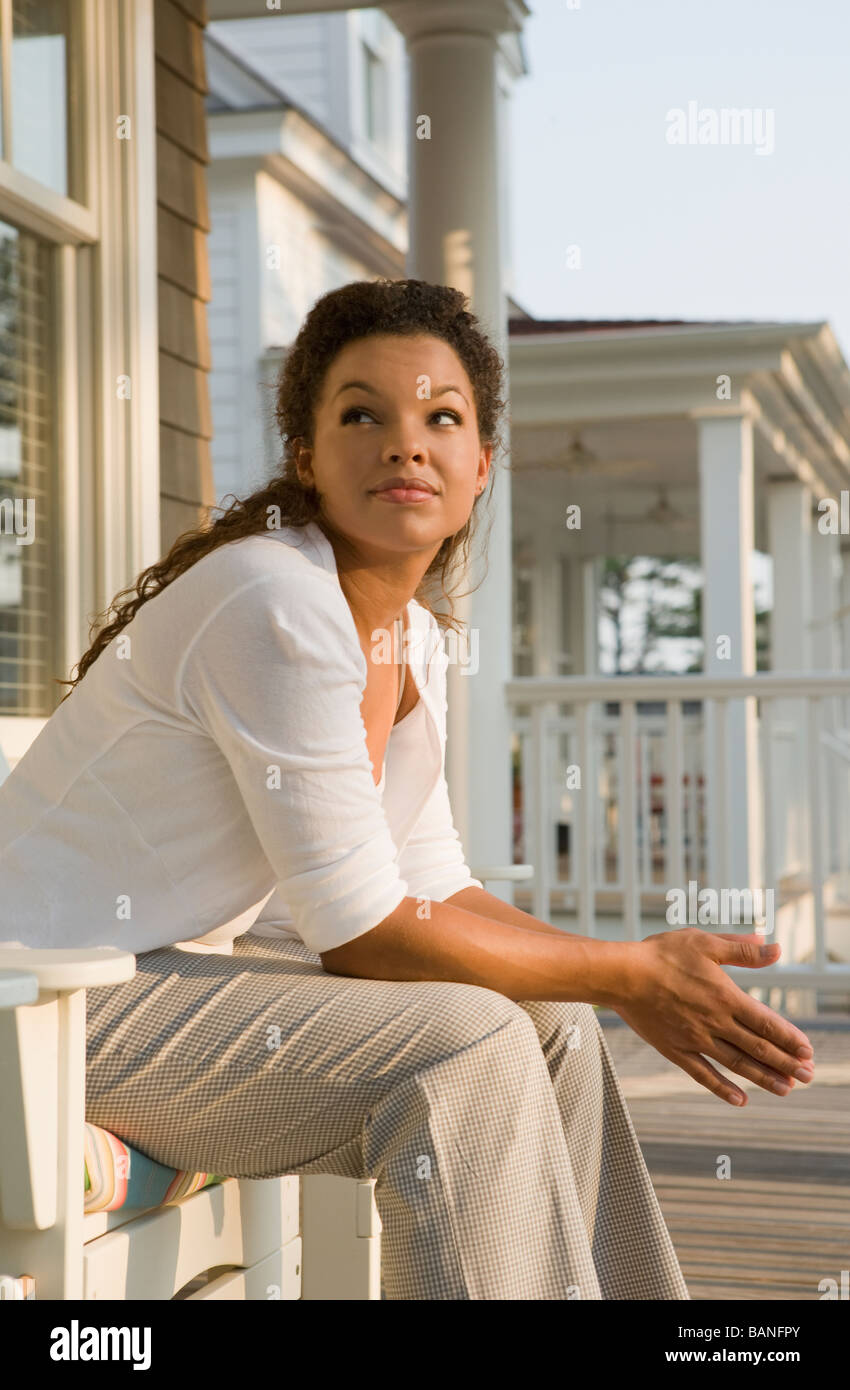 Mixed race woman sitting on porch Stock Photo - Alamy
