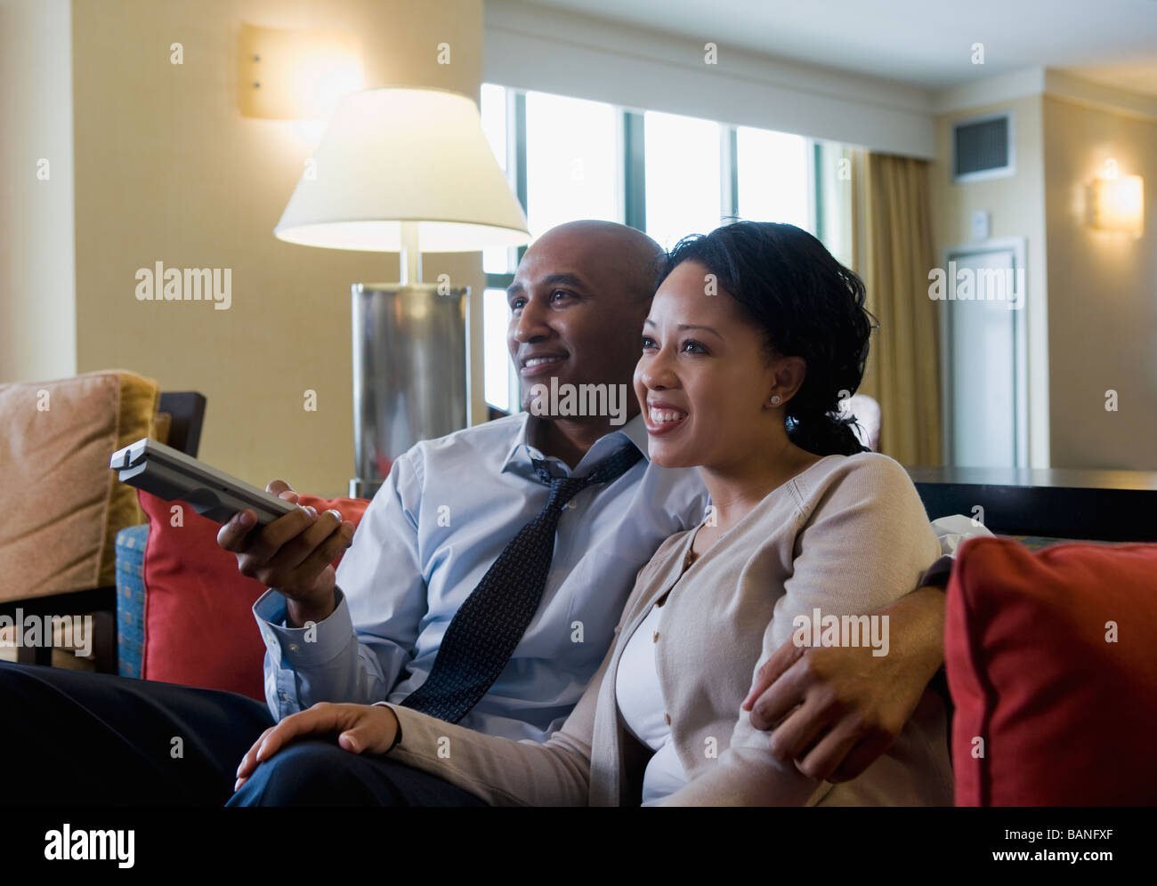 African couple watching television Stock Photo - Alamy