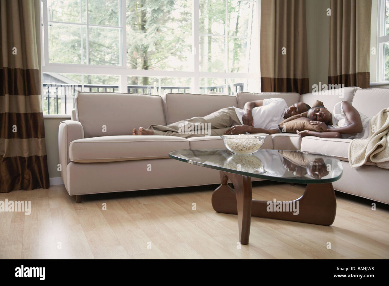 African couple sleeping on sofa Stock Photo - Alamy