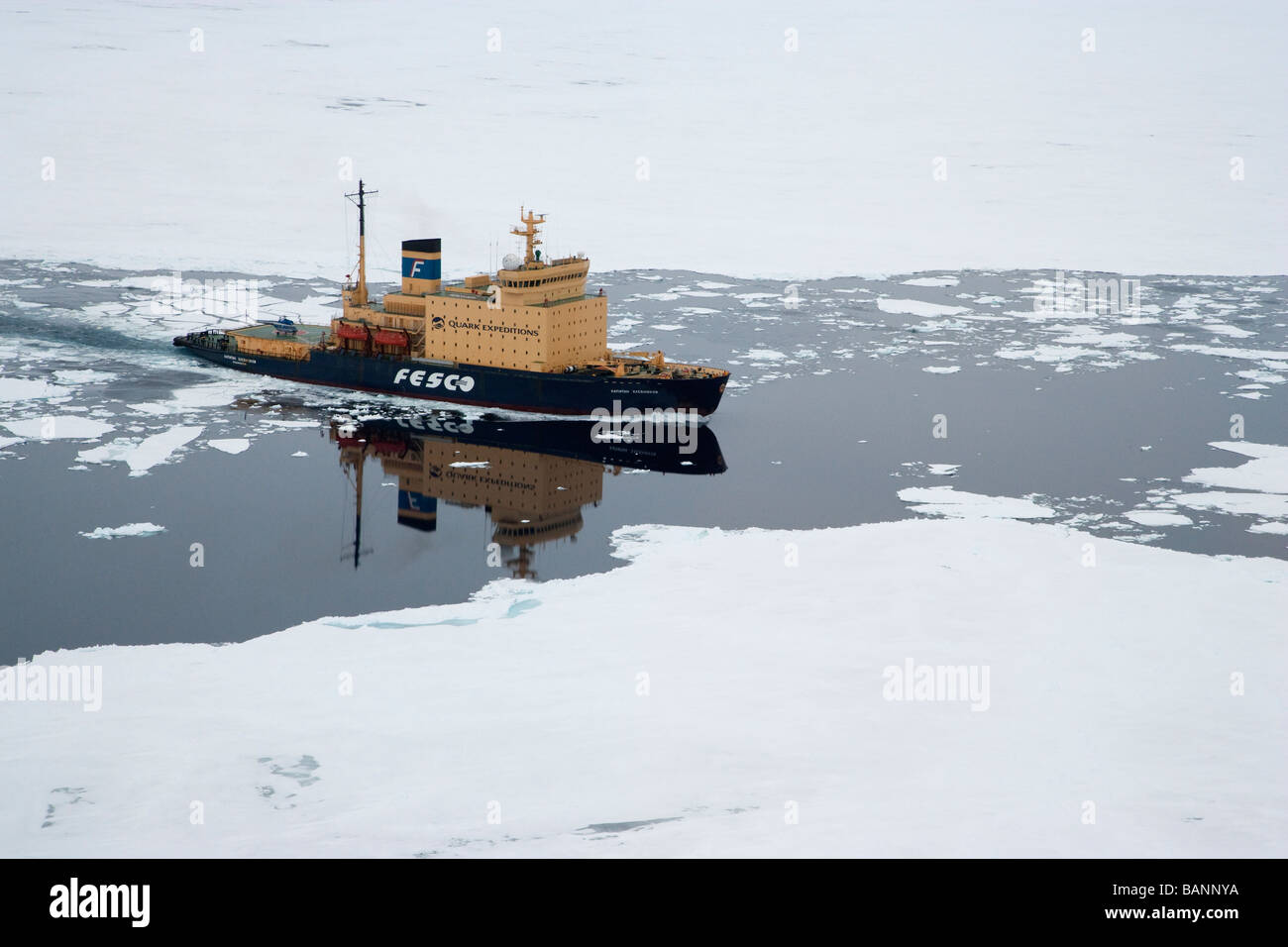 Icebreaker carrying tourist through Ice Flows of West Admunson Sea Antarctica reflected in calm waters of open leads Stock Photo