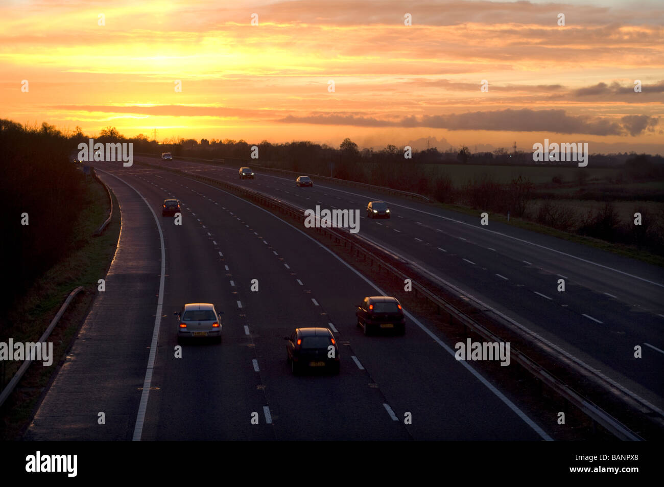 Road traffic on the M5 motorway at sunset, near Dursley, Gloucestershire. Stock Photo
